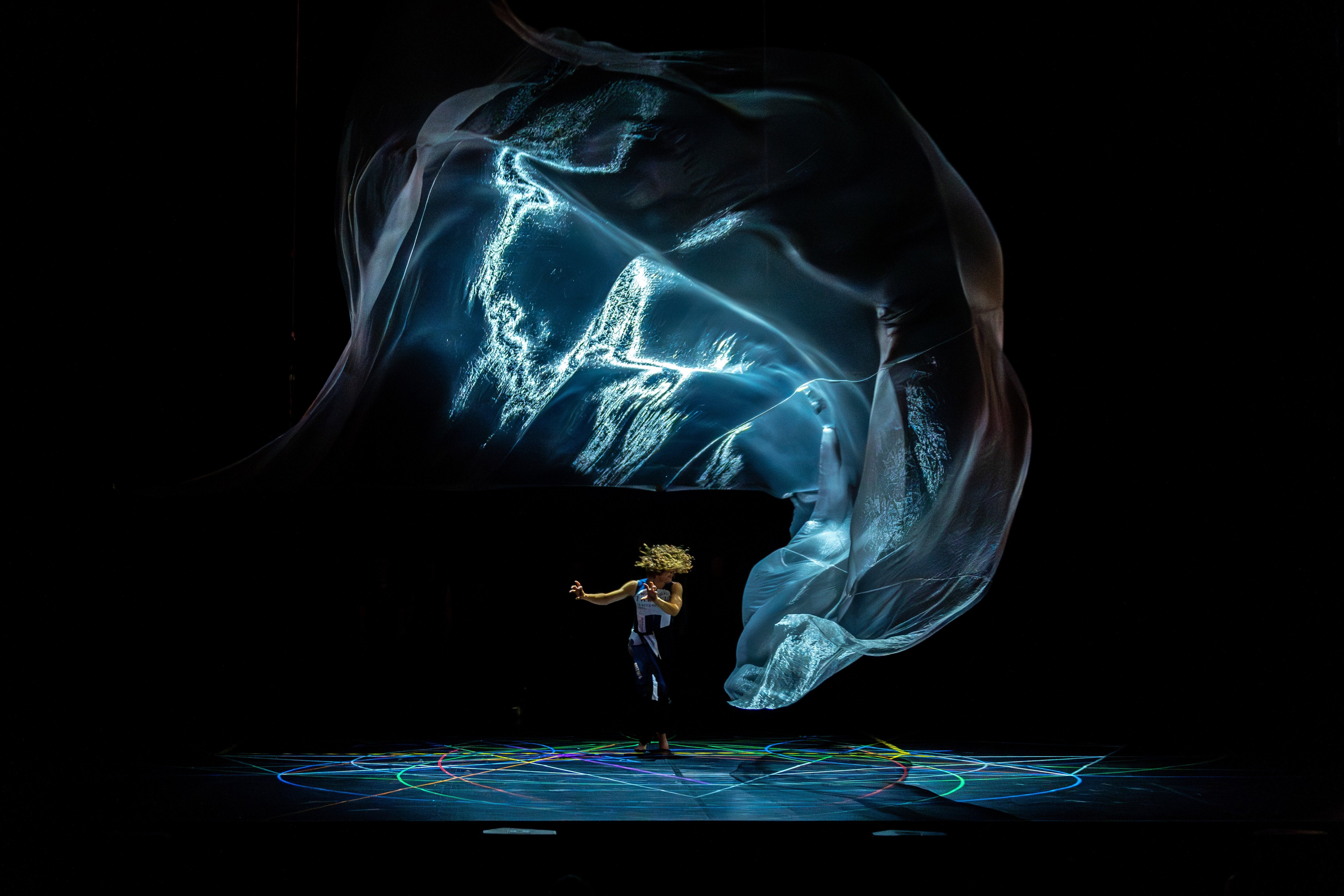 Danseuse de profil sous une projection lumineuse sur scène