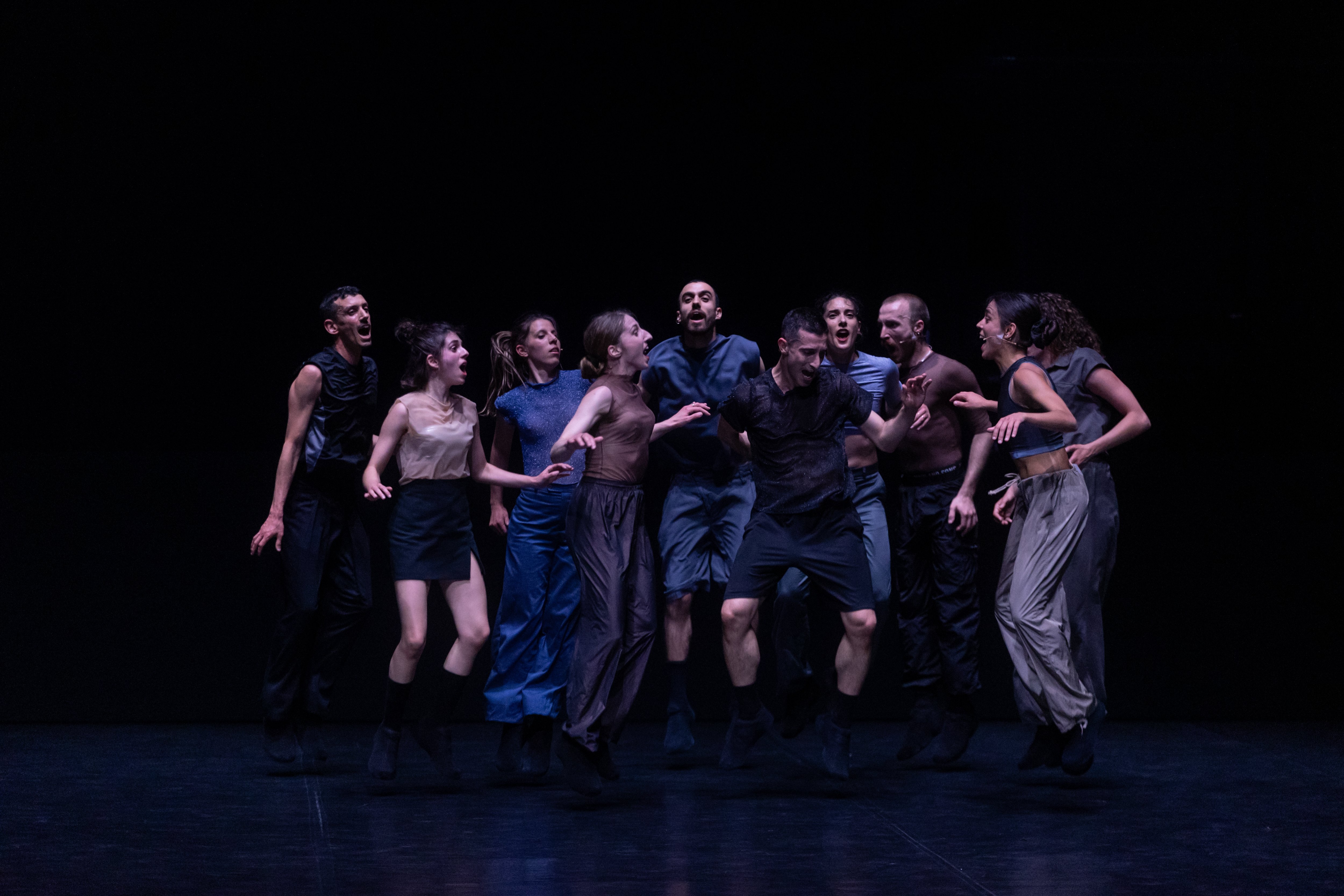 ten people grouped together jumping on a black background