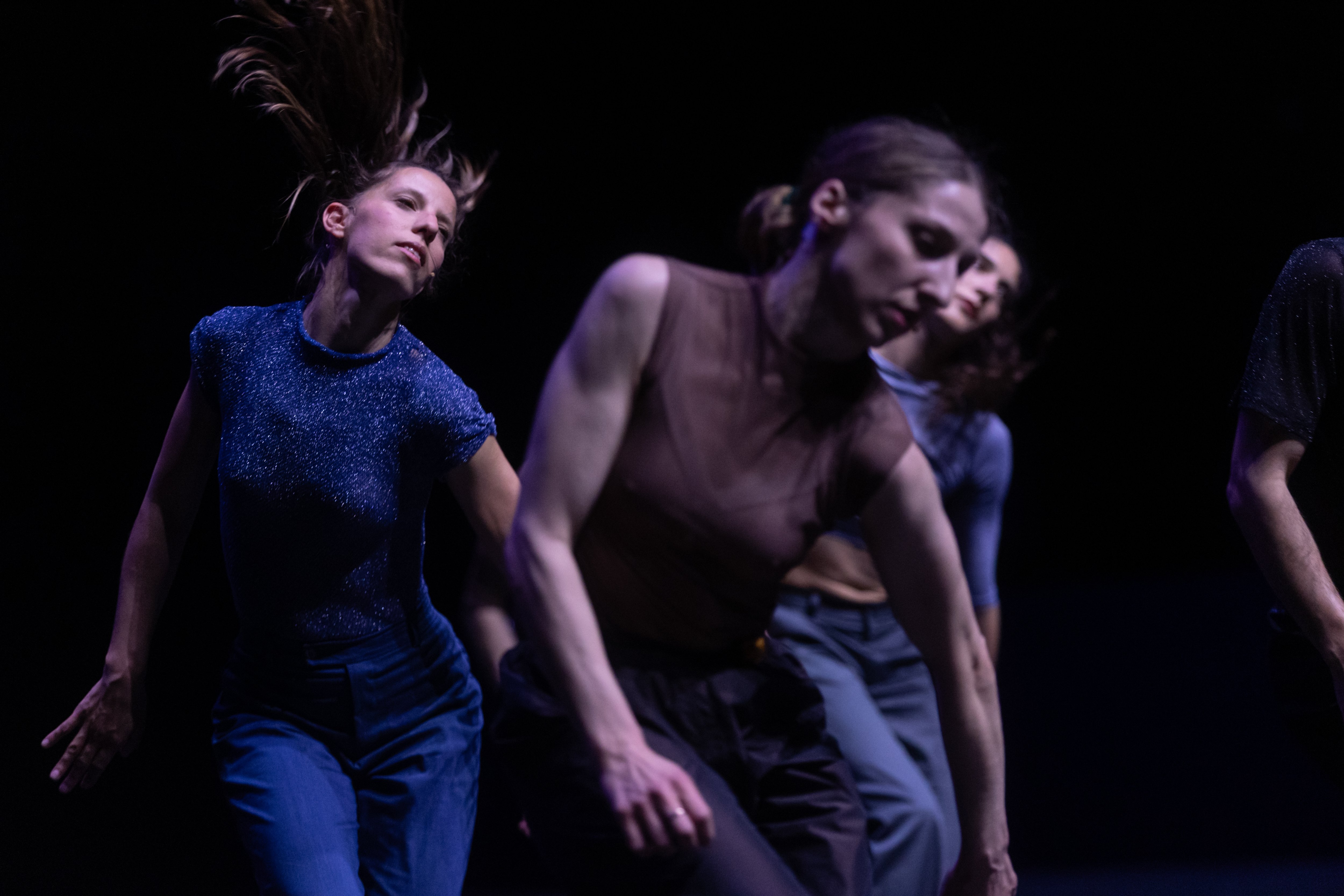 three women dancing on a black background