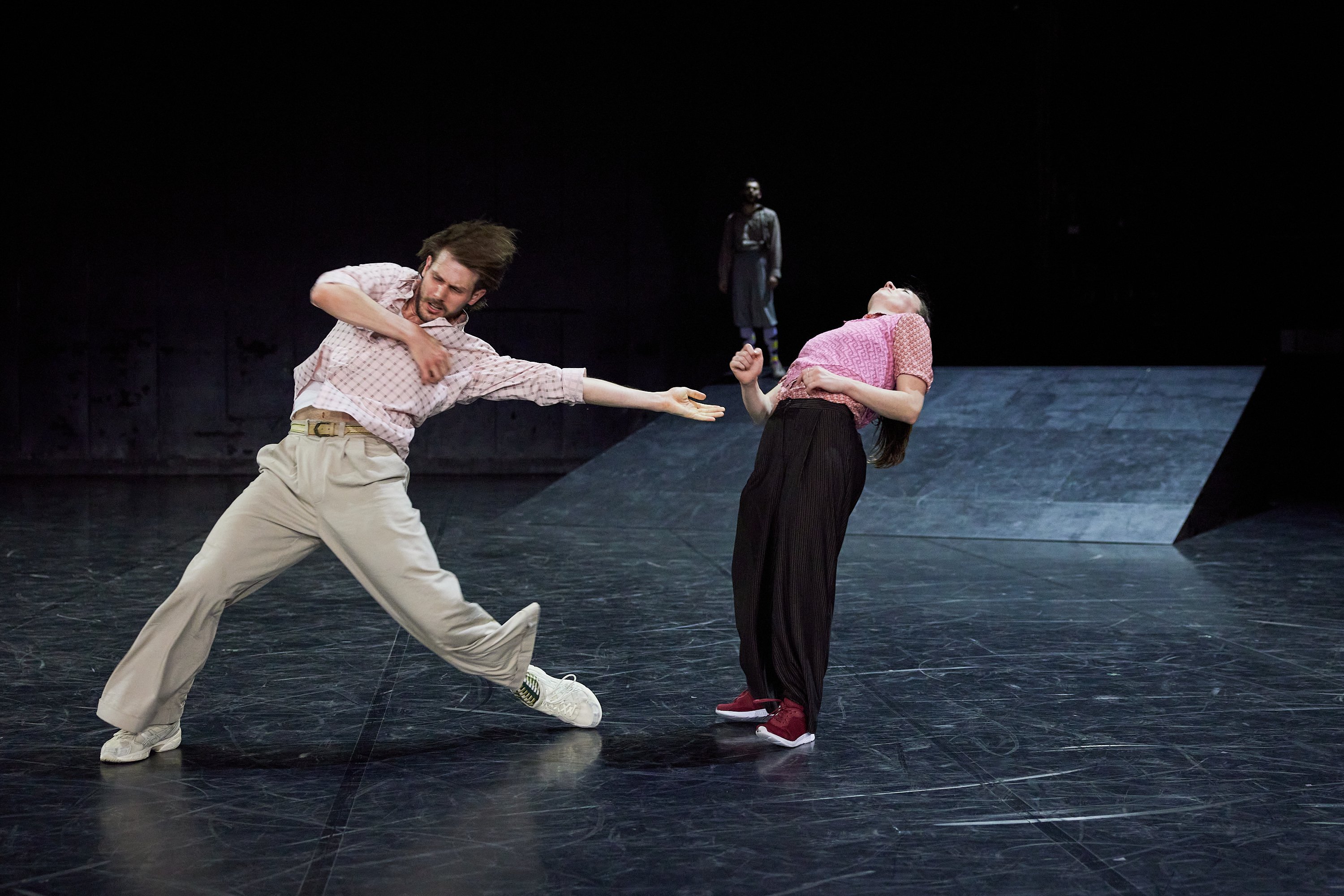 A man in beige attire and a woman falling