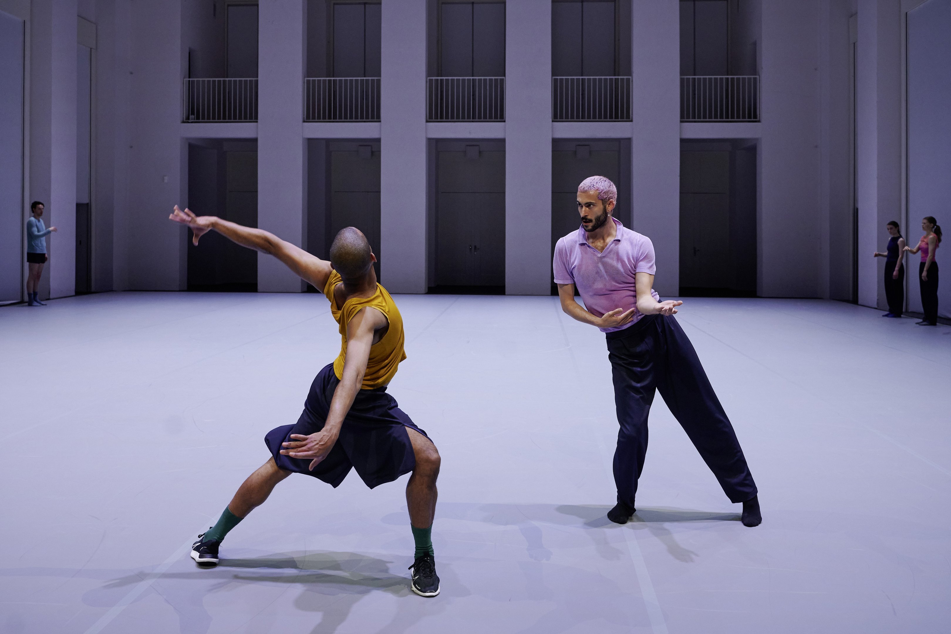 deux danseurs, un avec un haut violet et l'autre jaune
