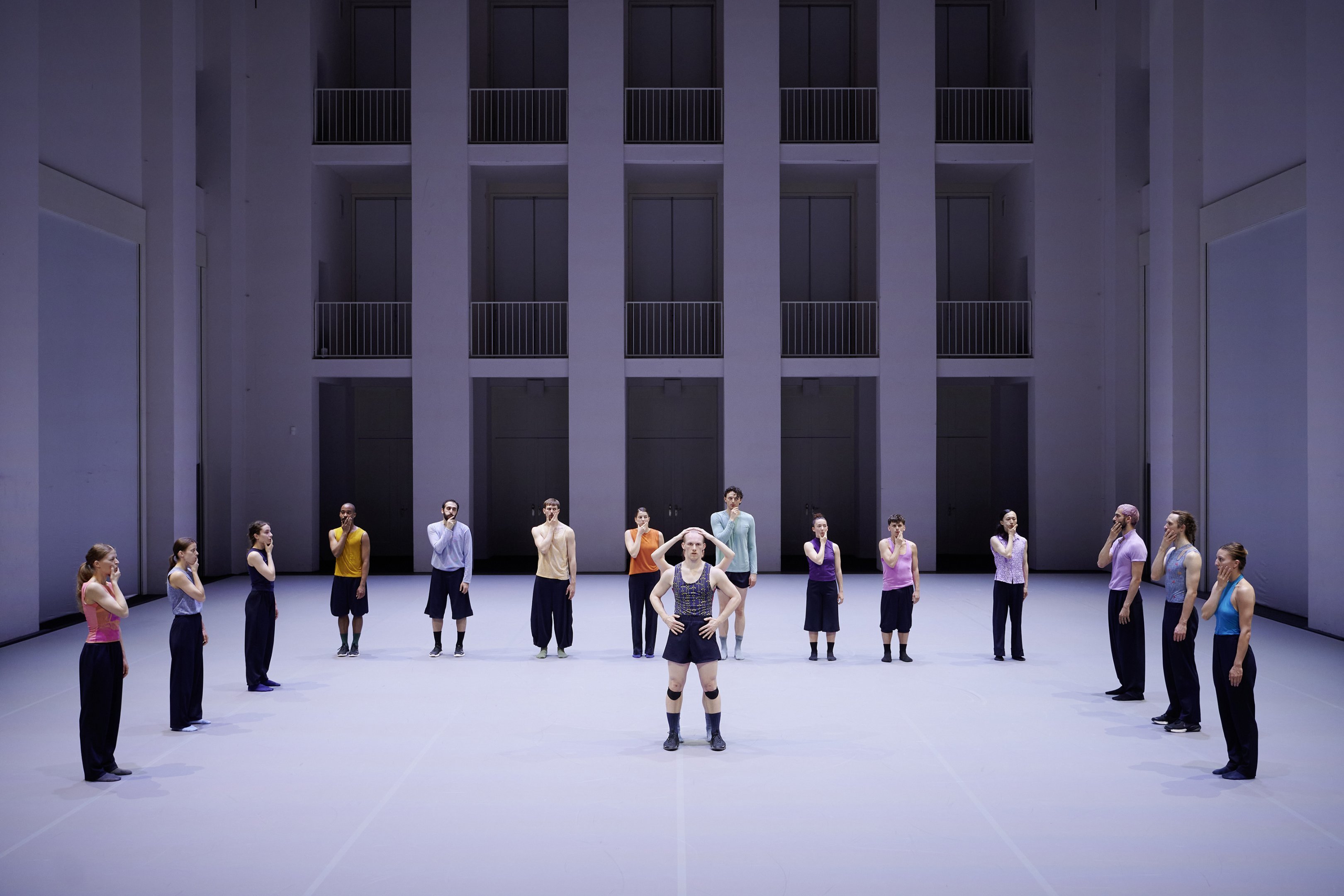 A dancer standing in the middle of the others in a line around him