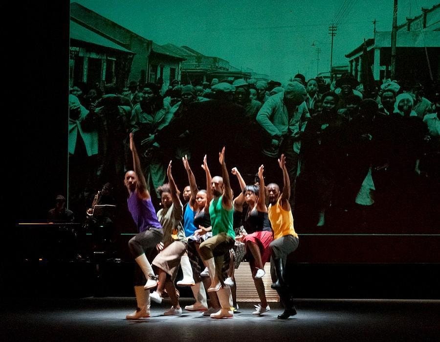 a group of dancers performing in front of a archival image