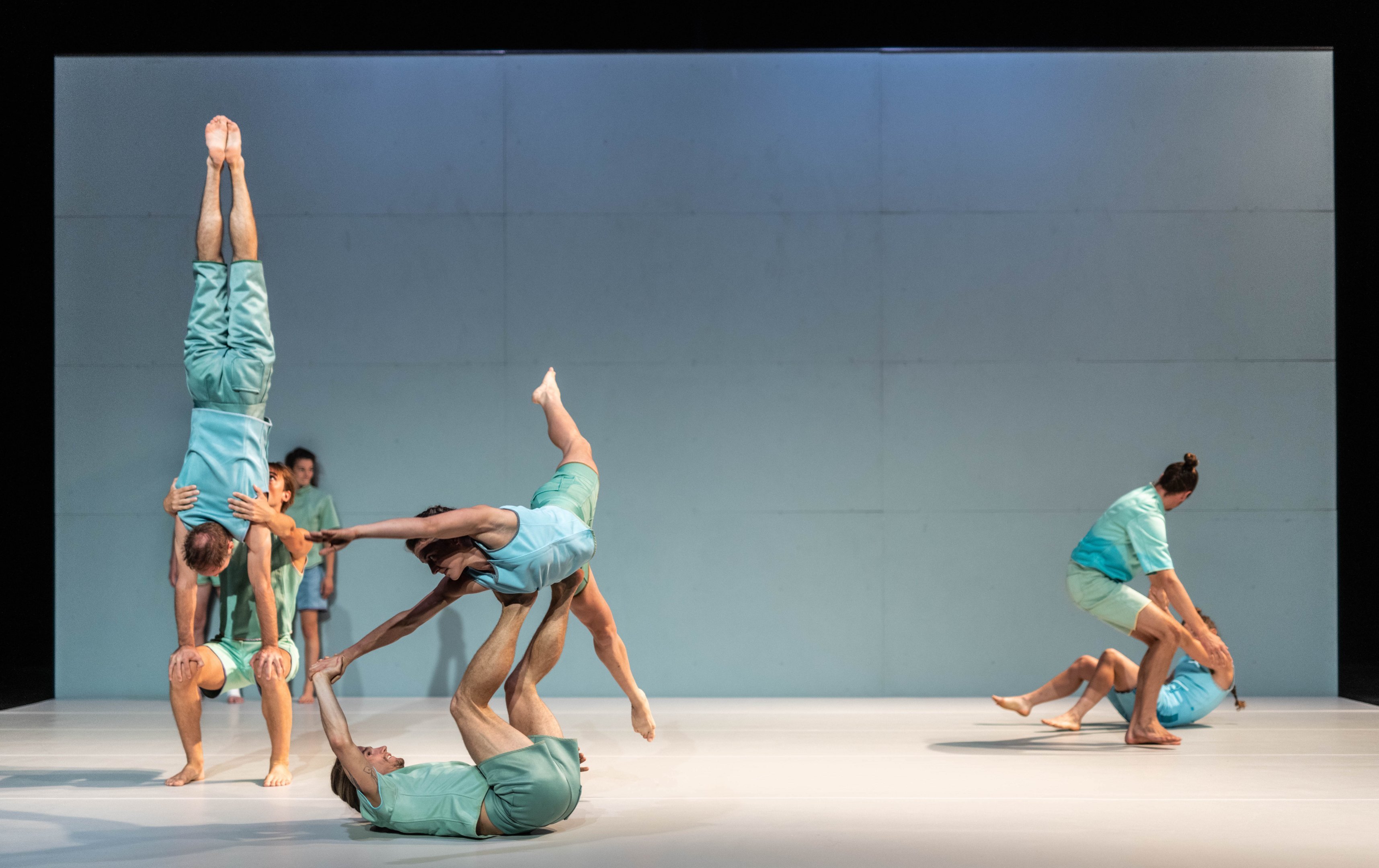 Several duos of dancers performing lifts