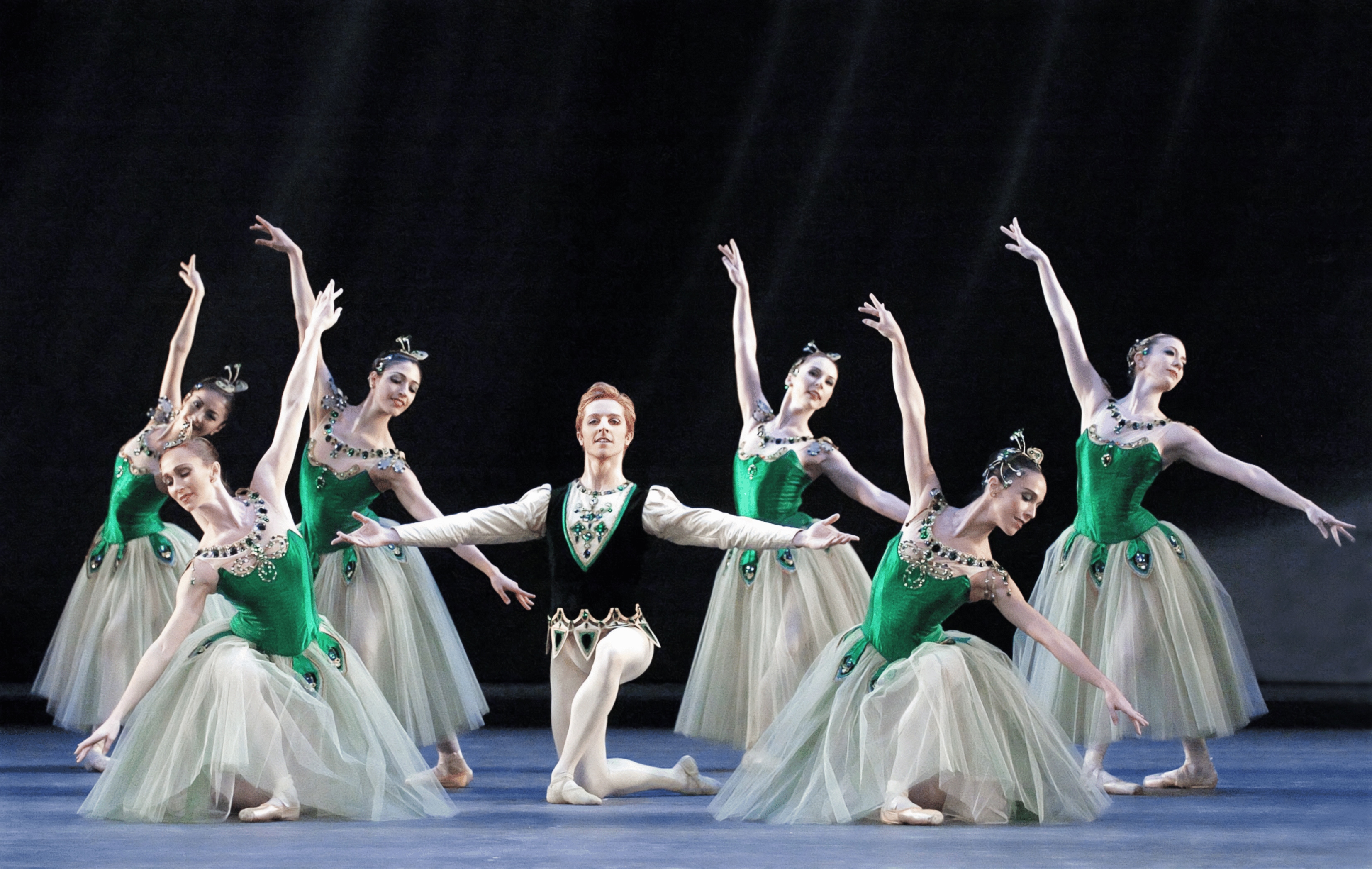 Photo d'une représentation du ballet Joyaux montrant un danseur entouré de danseuses en costumes verts