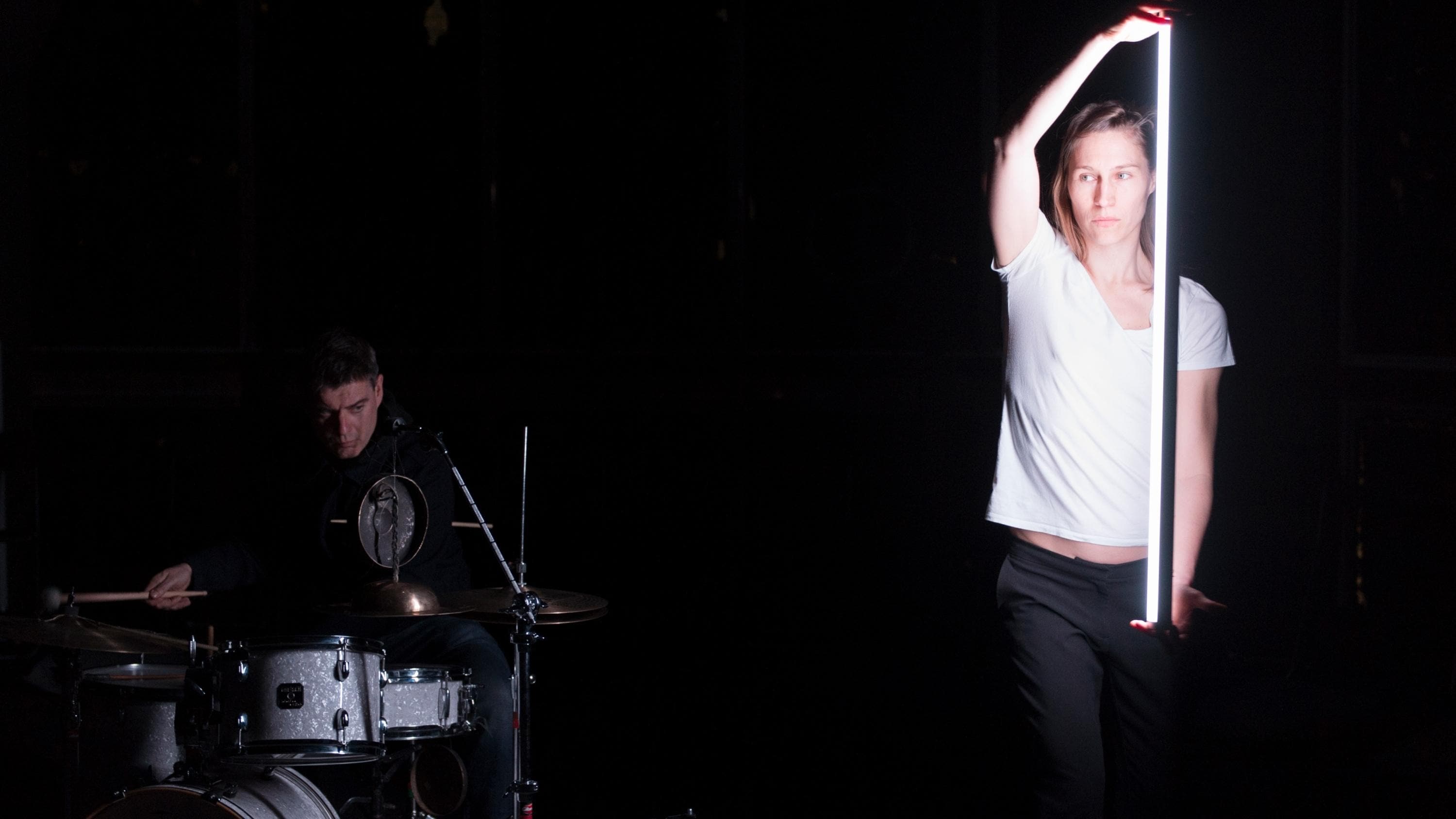 《围绕》（All Around）中，Will Guthrie在演奏鼓乐，Mette Ingvartsen握着一支灯光杆