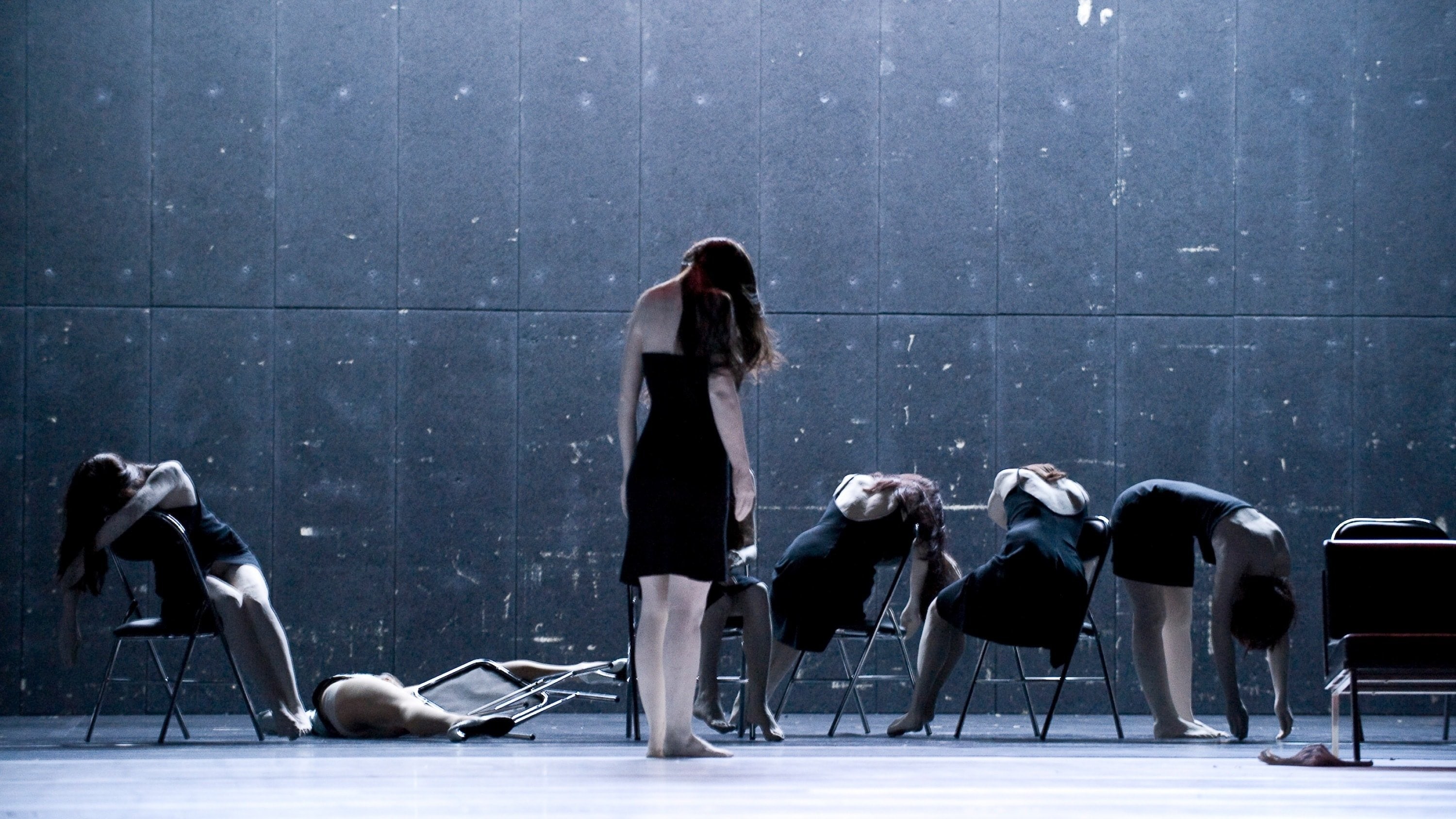 Women in black upon chairs in Showroomdummies by Gisèle Vienne