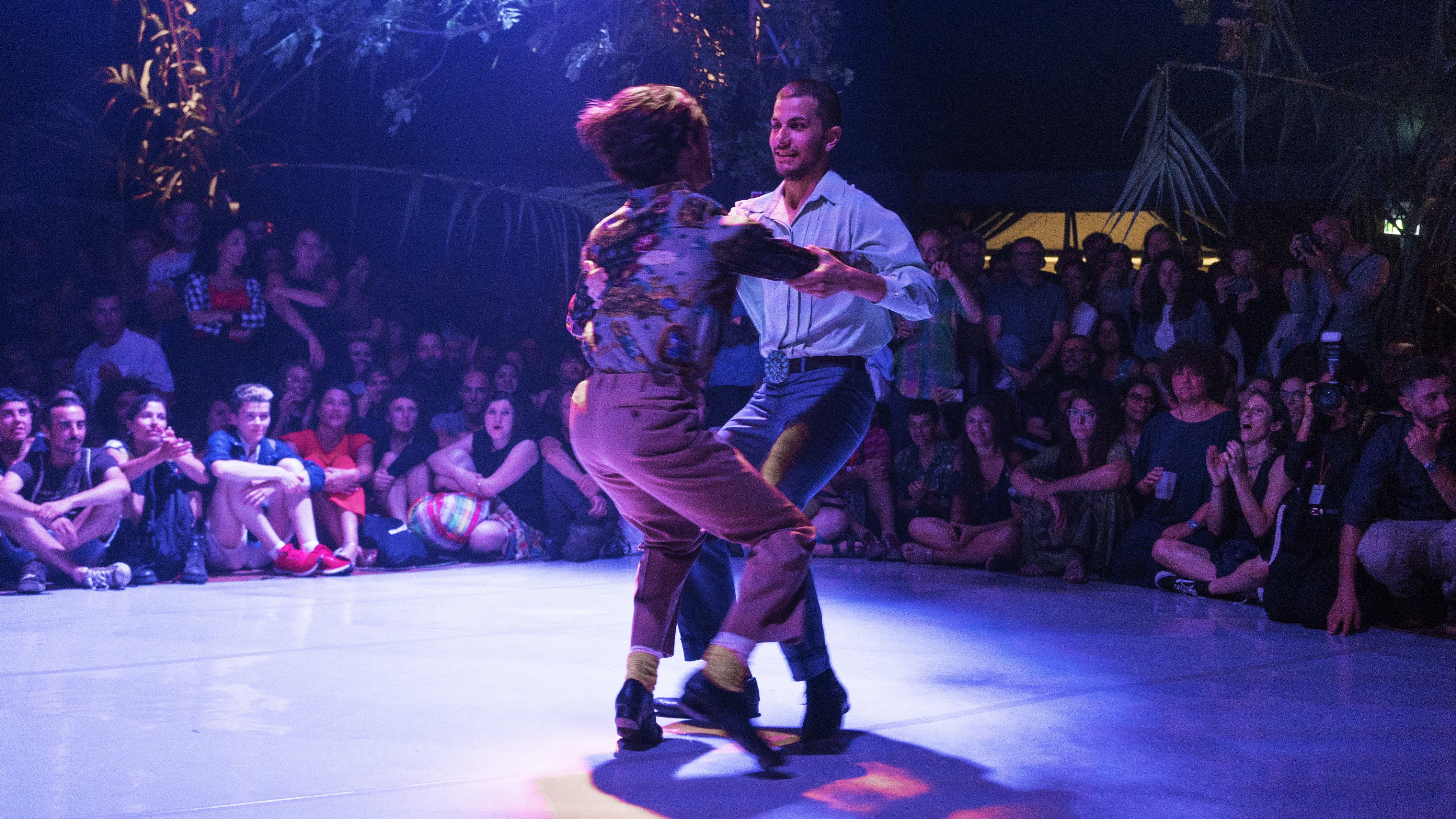 Deux danseurs tournoyant au milieu d'une foule