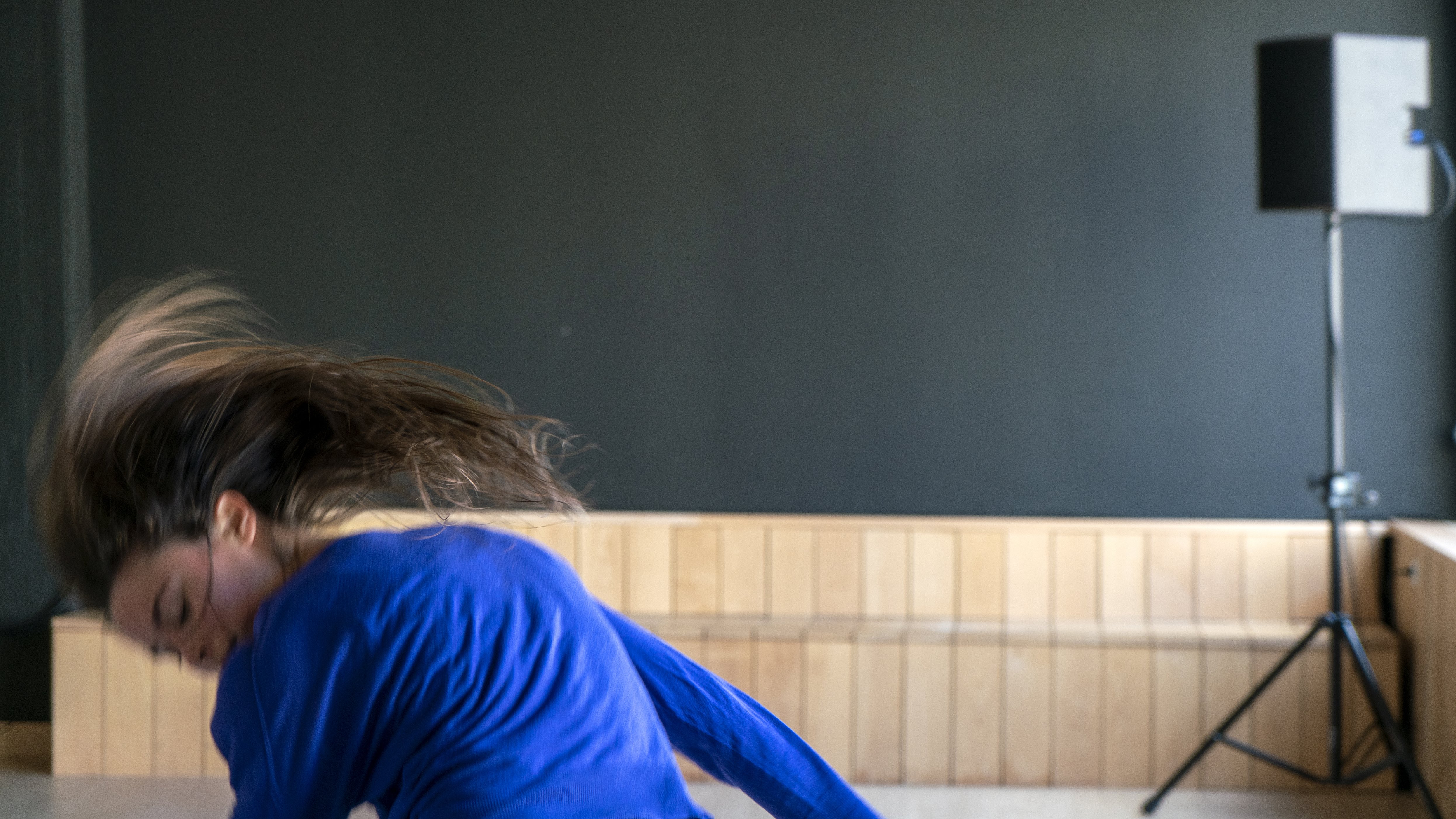 dancer with blue shirt moving fast downwards