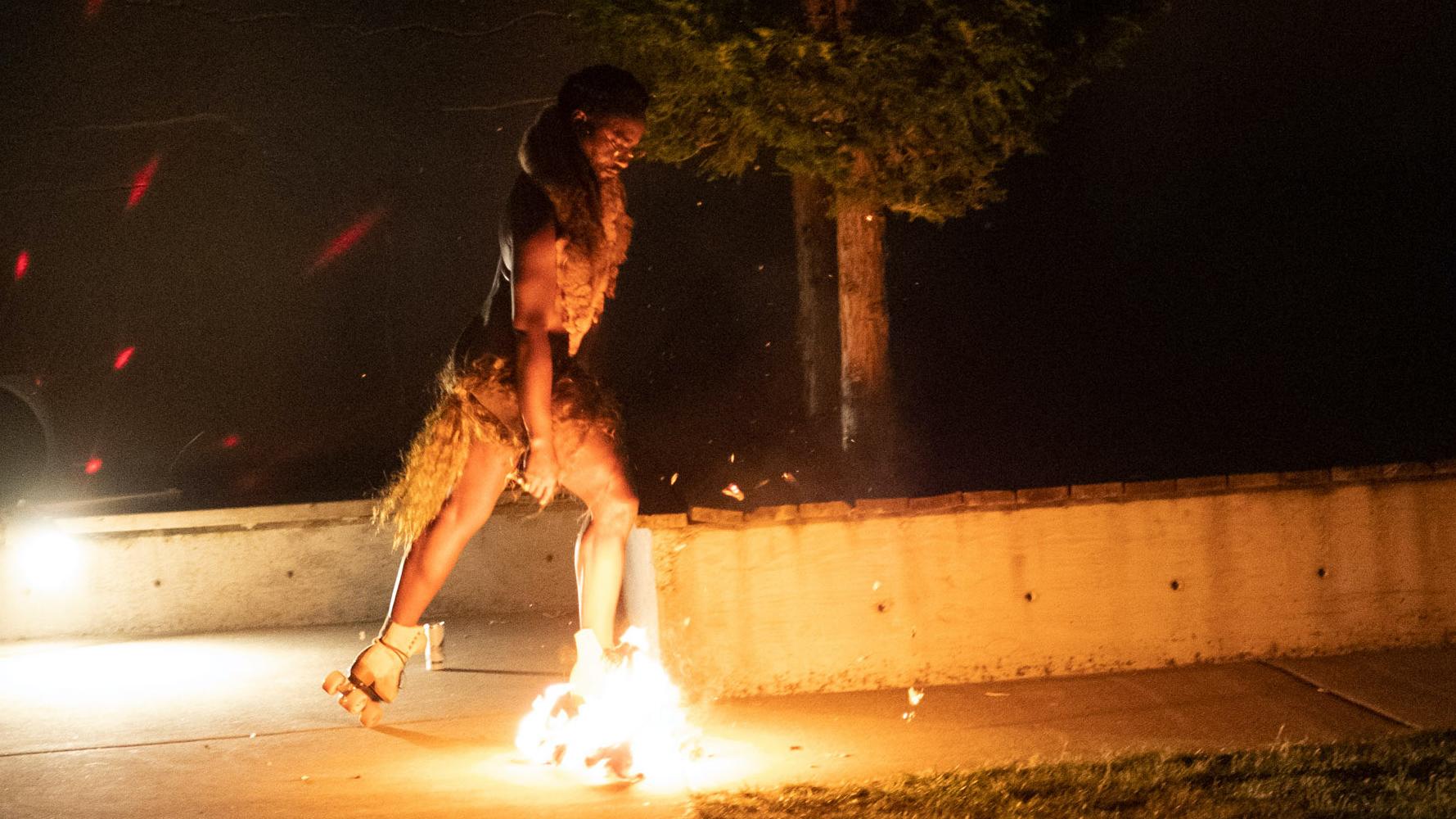 晚间表演轮滑的舞者，其中一只鞋子上着有火焰