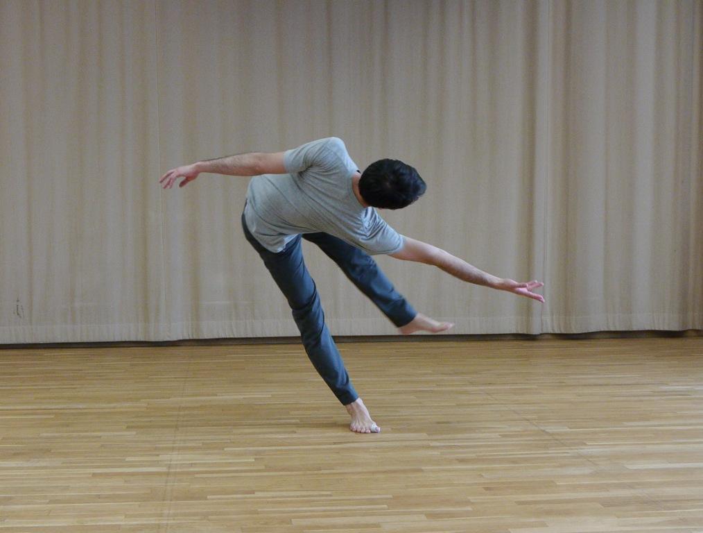 舞者開始進行旋轉動作，身軀和手臂向後擺。