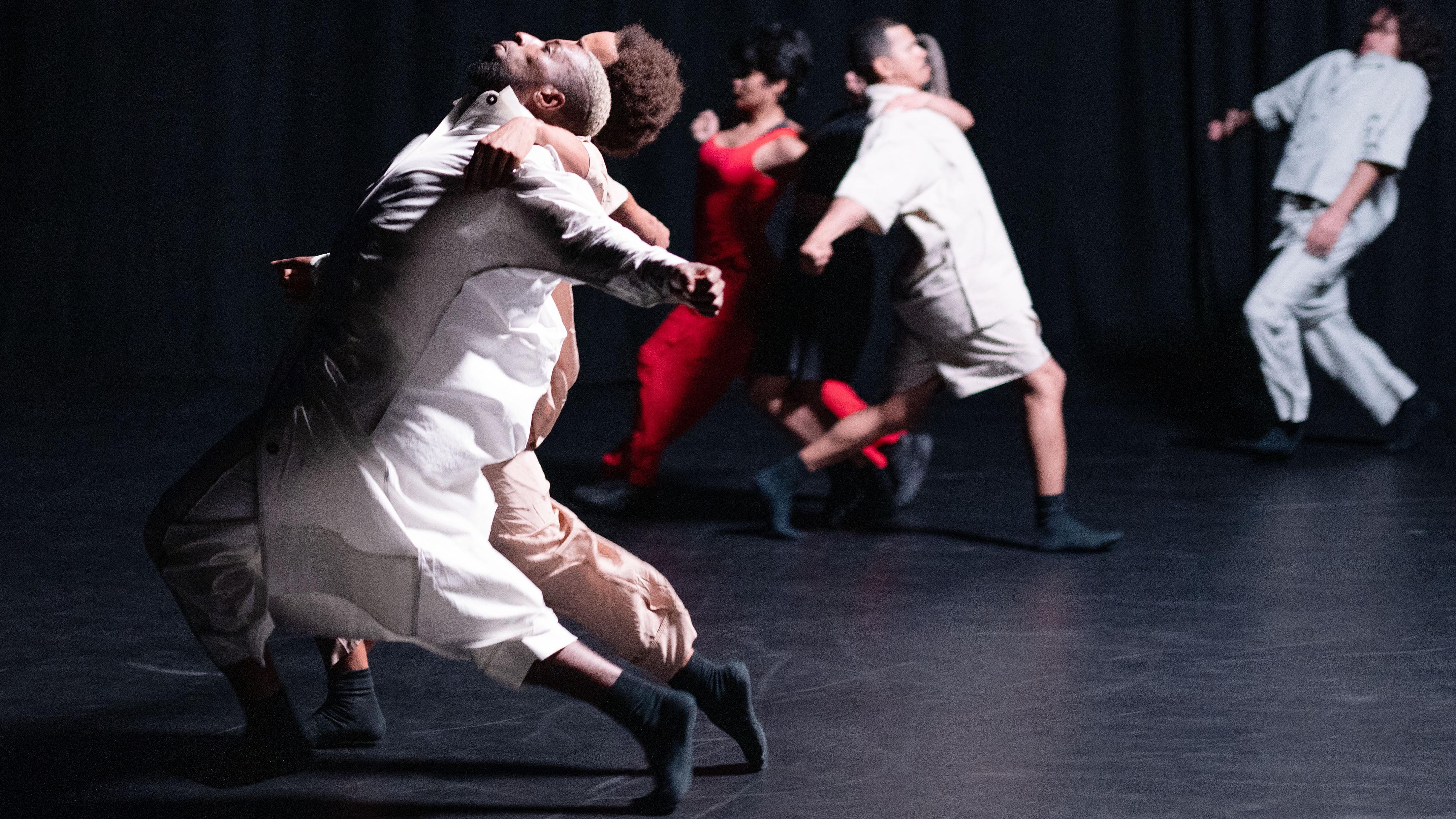 Danseurs vêtus de blanc, penchés vers l’arrière