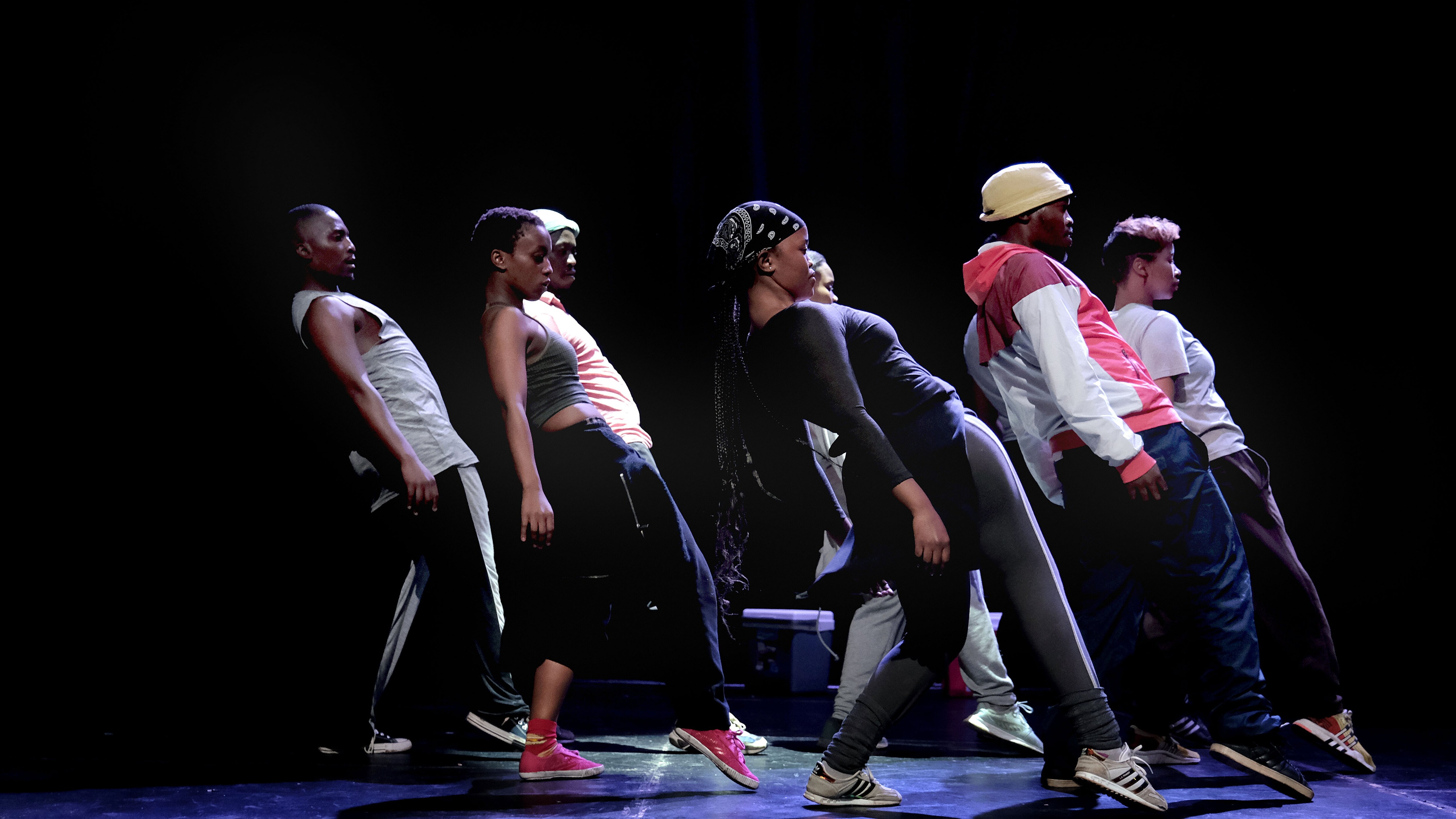 Dancers leaning backward with one leg stretched out in front in Via Injabulo 