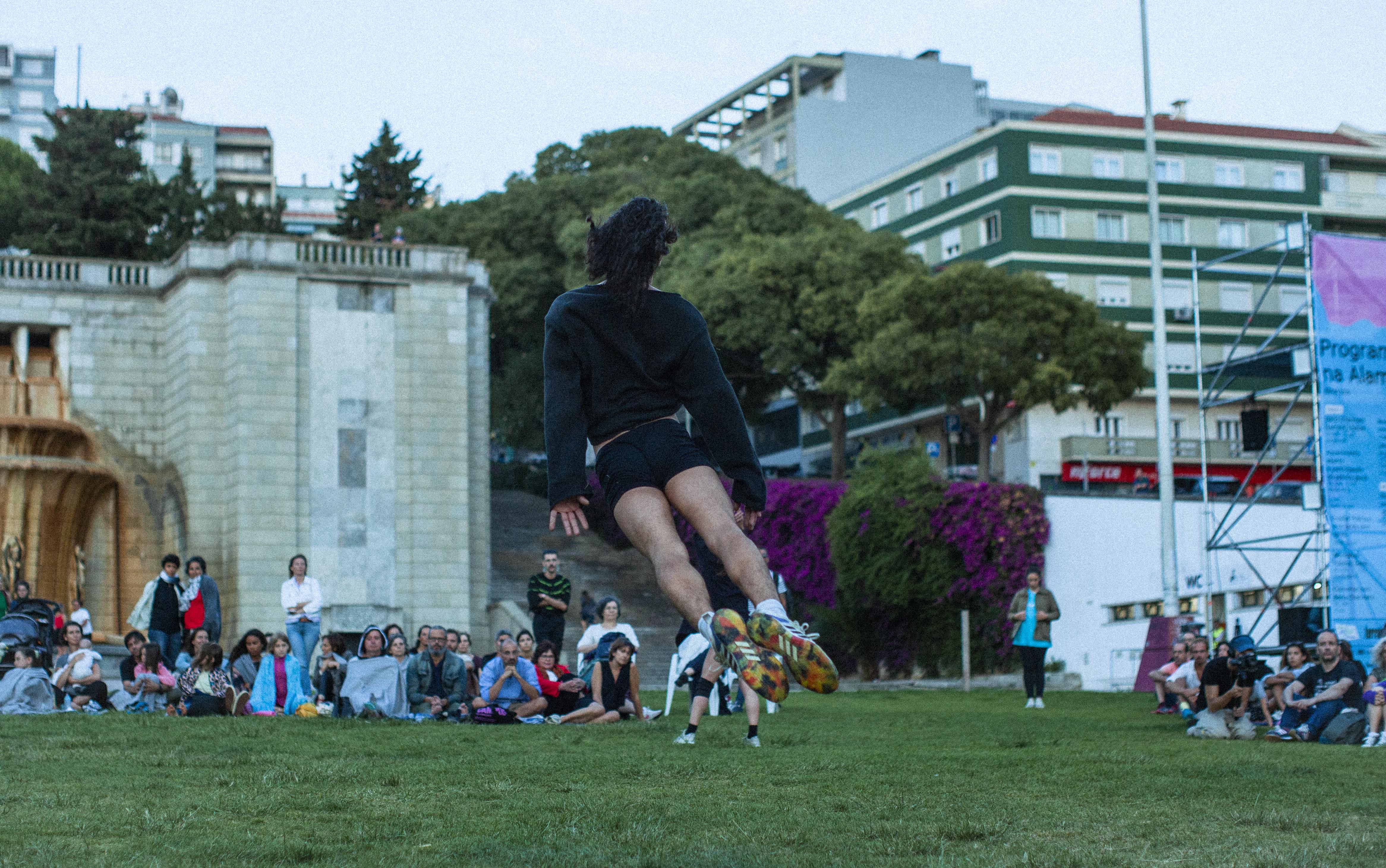 Danseur de dos sautant dans un jardin