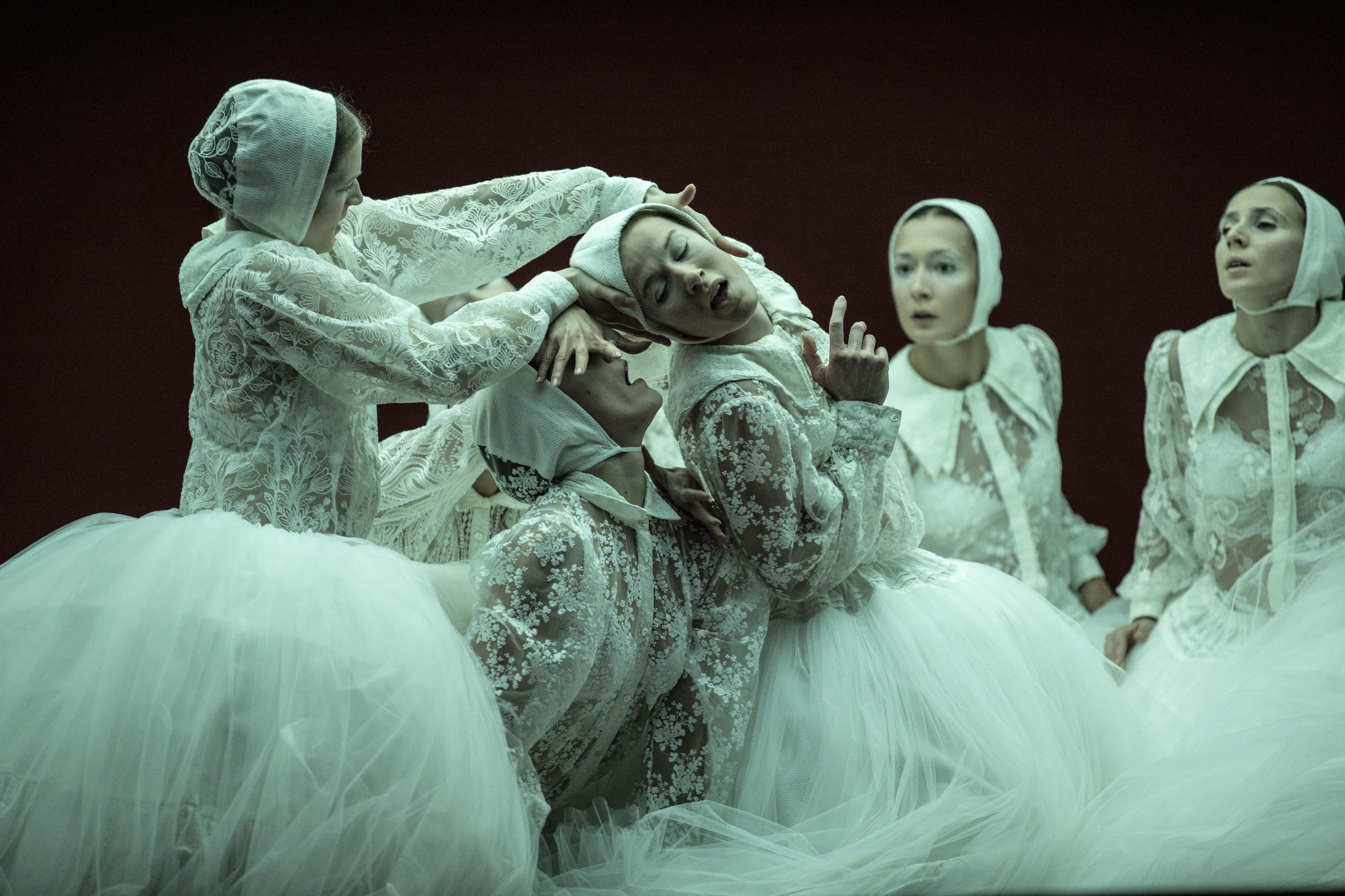 Danseuses vêtues de tutus et de hauts en dentelle blanche penchées les unes sur les autres