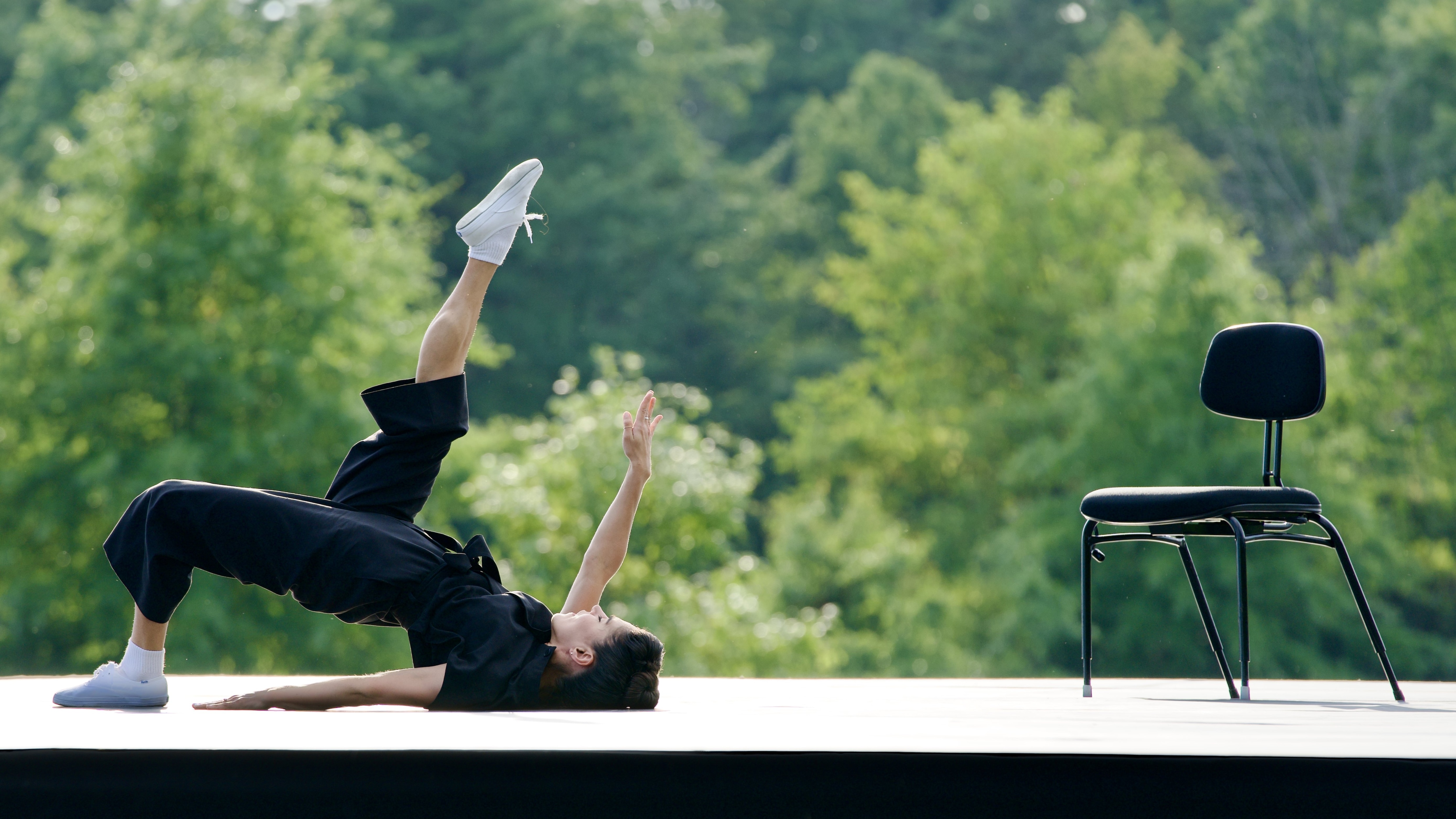 Danseuse au sol à côté d’une chaise au parc culturel Kaatsbaan