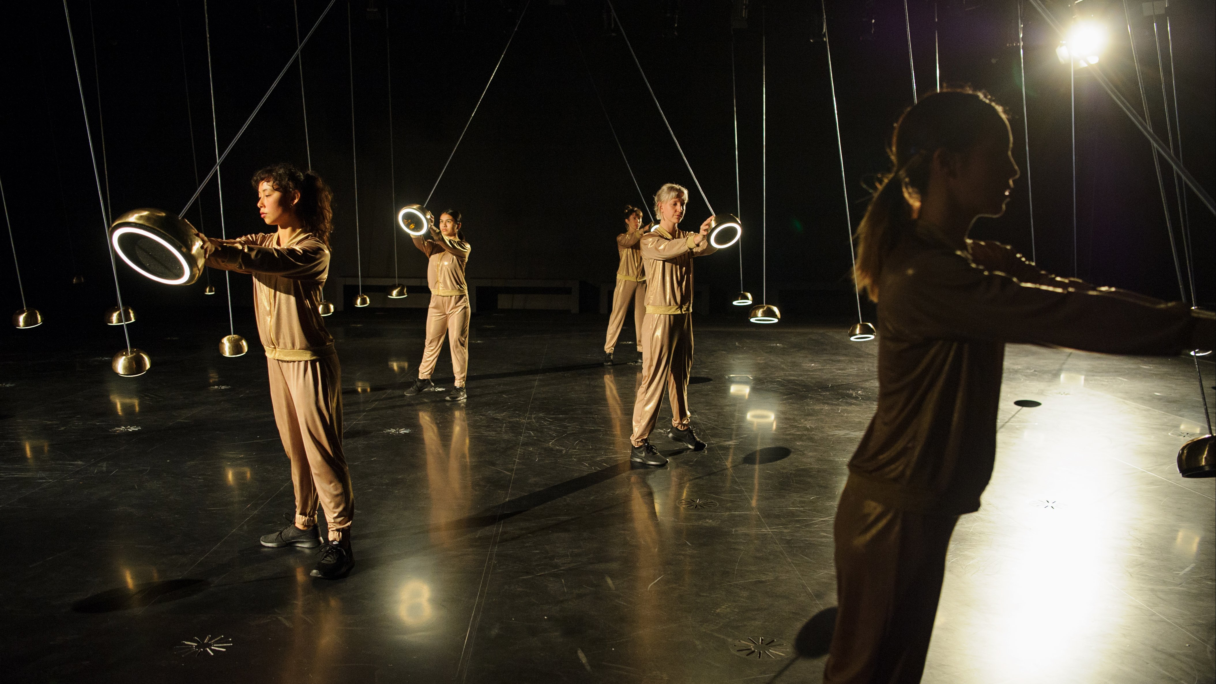 Dancers each holding a pendulum