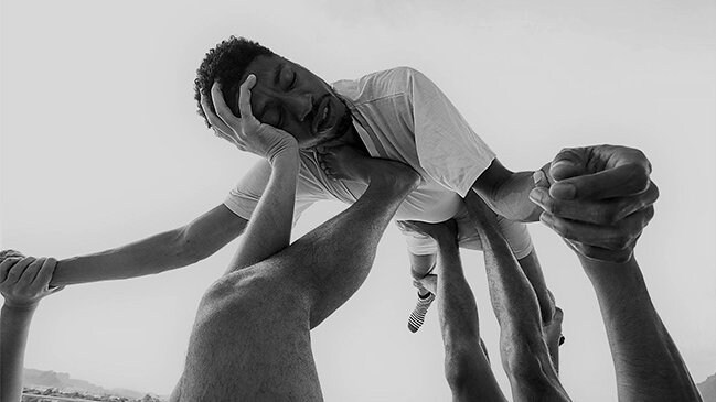 Danseur tenu dans les airs par plusieurs bras et jambes