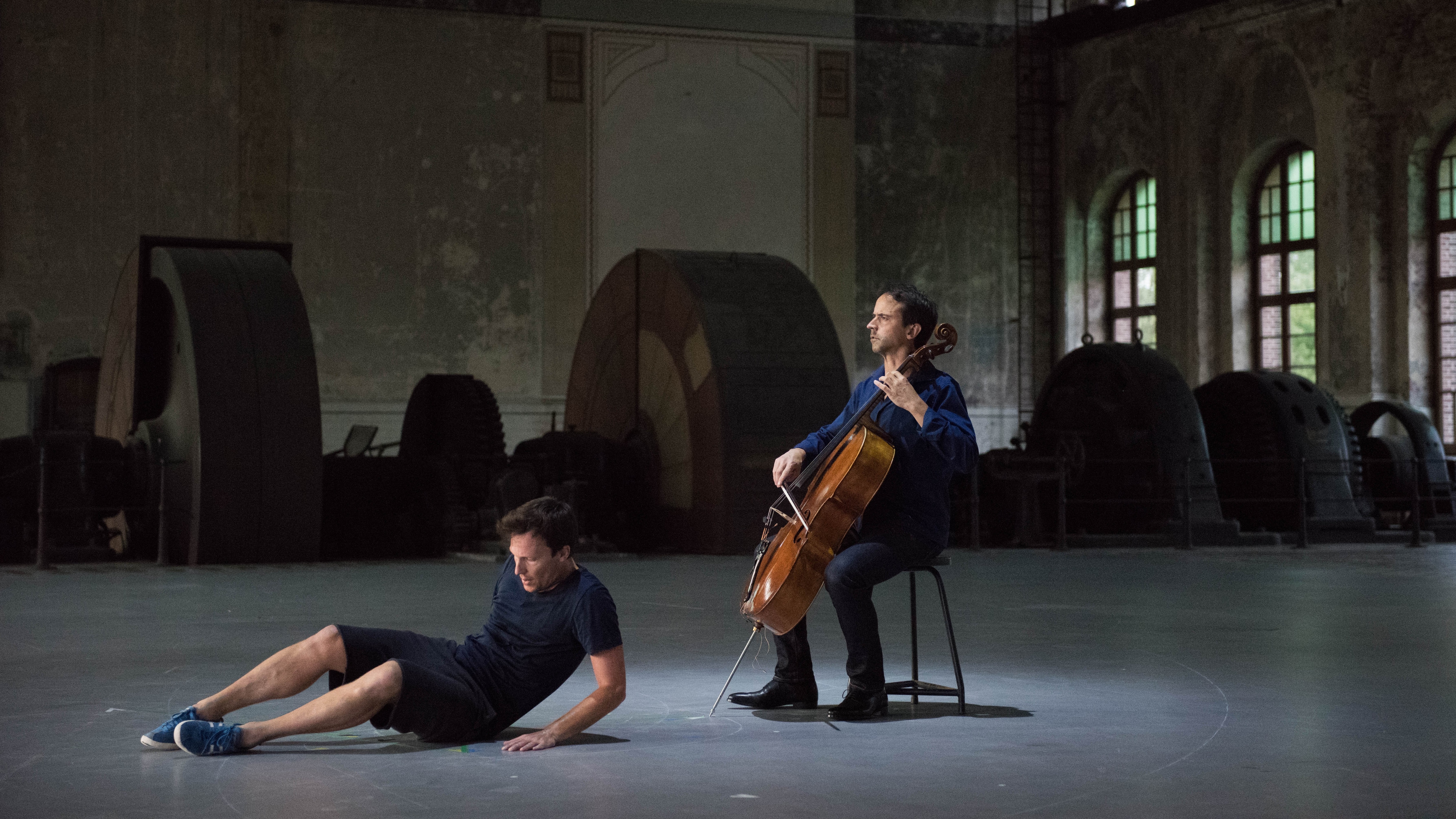 Danseur sur le sol devant le violoncelliste Jean-Guihen Queyras