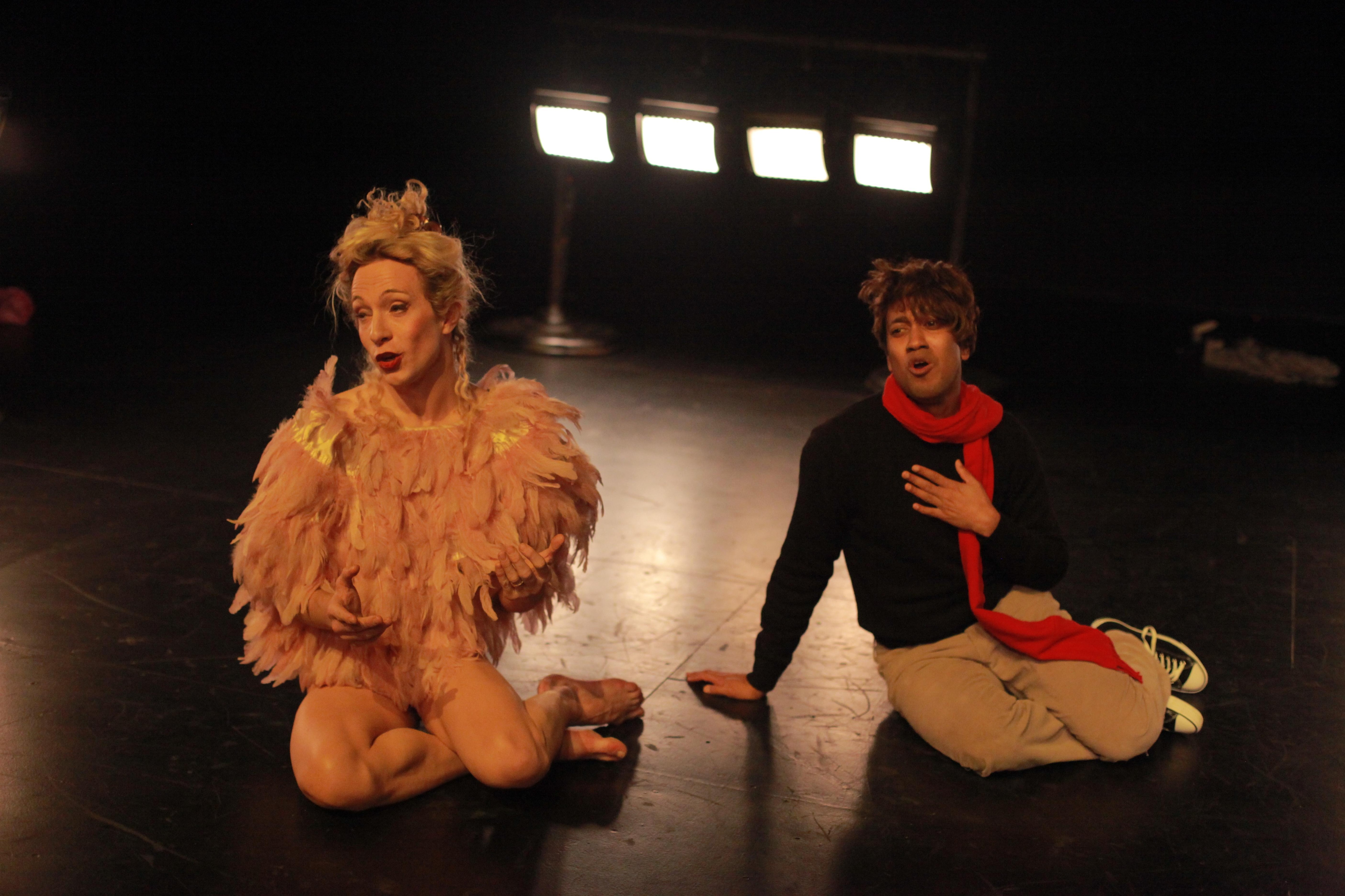 Two dancers sitting on the floor, mouths agape