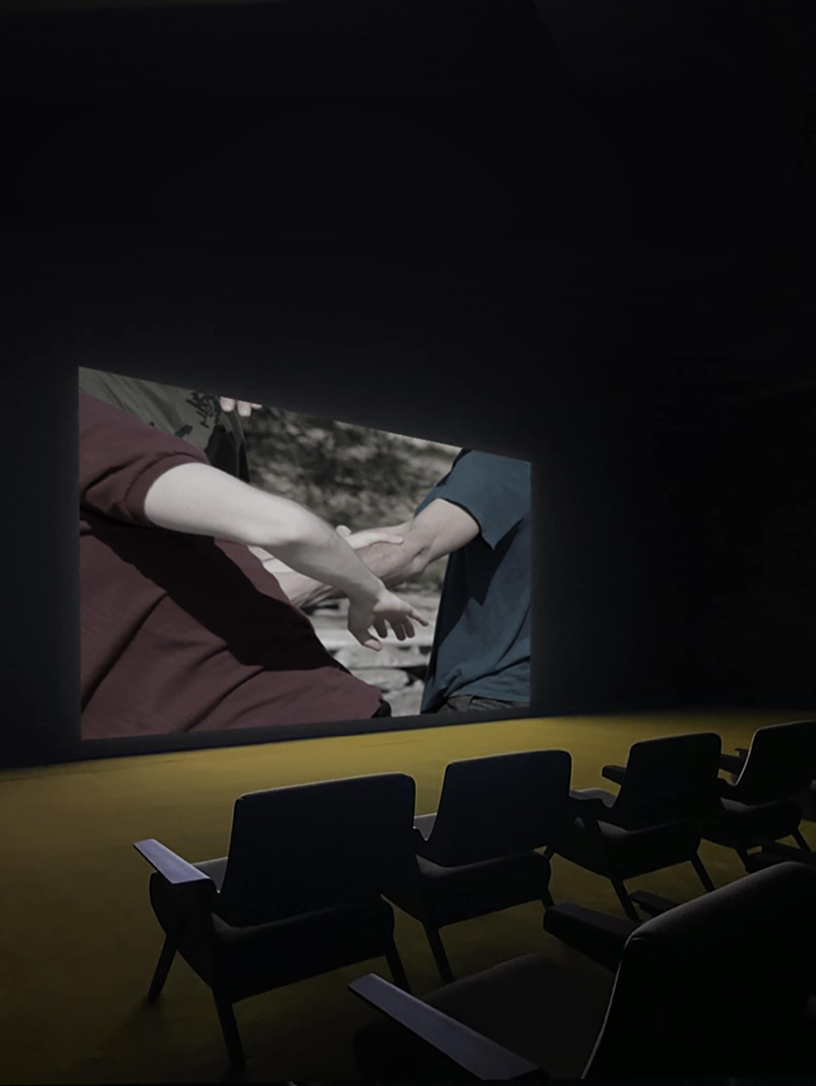 Projection d’un film de danse devant une salle vide.
