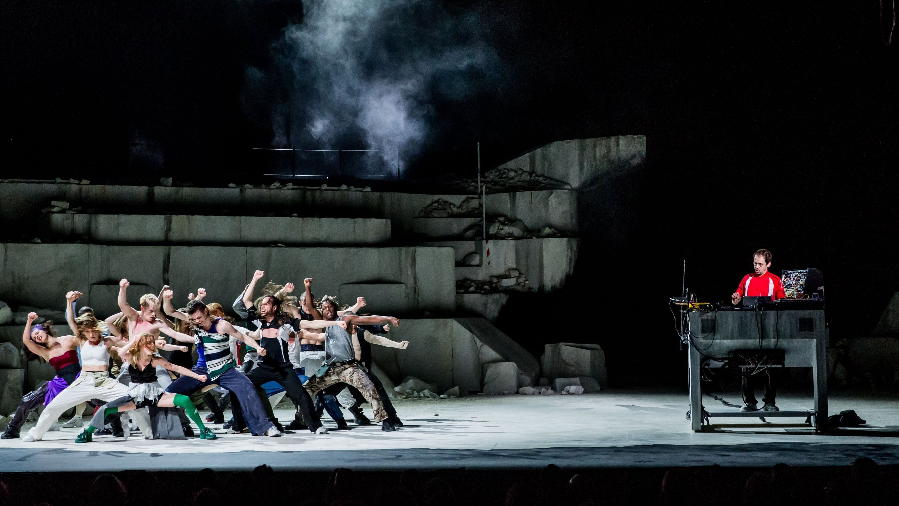 group of dancers on the left and a man on the right mixing.