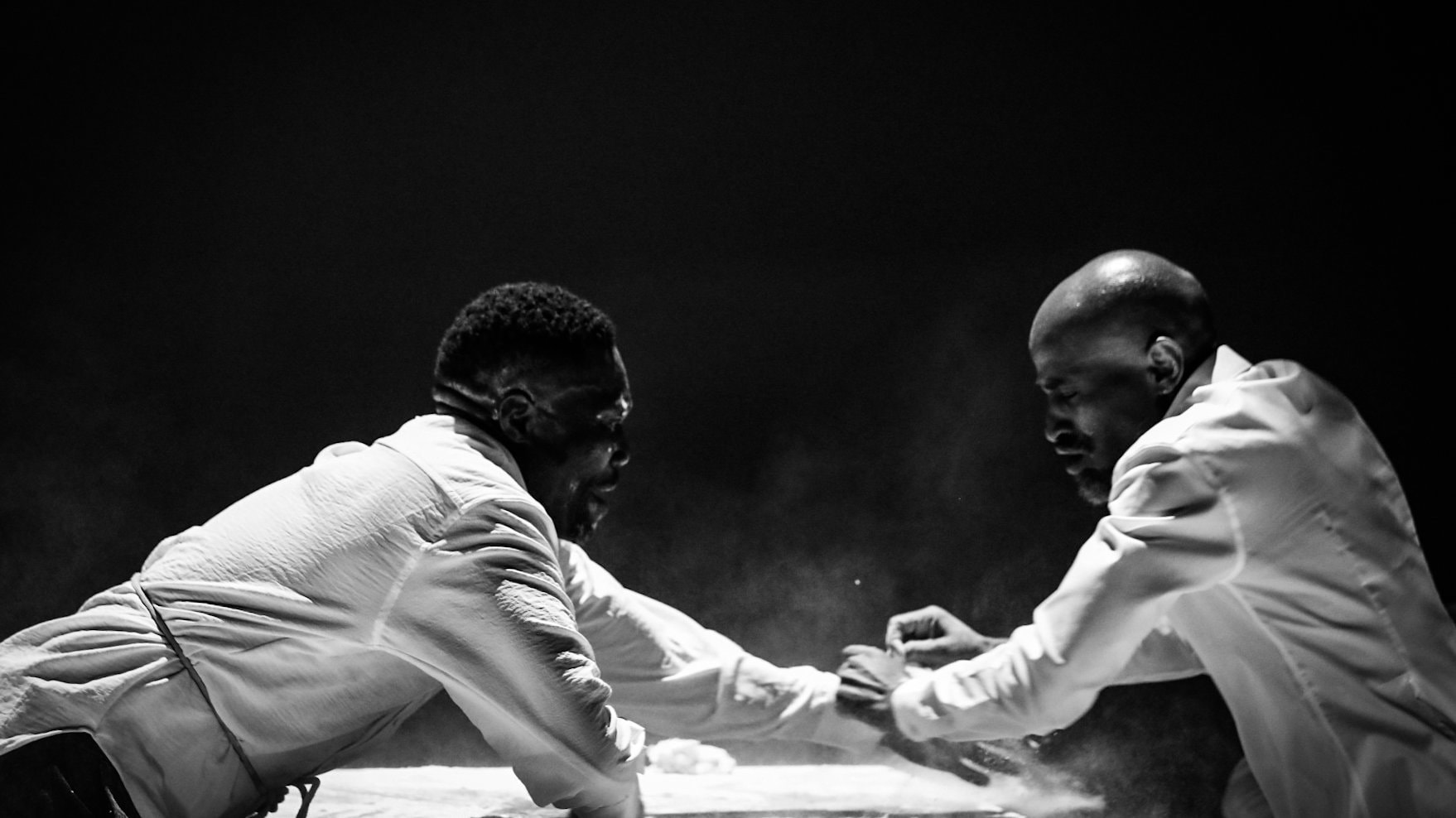 Deux hommes en chemises blanches à une table, photo en noir et blanc.