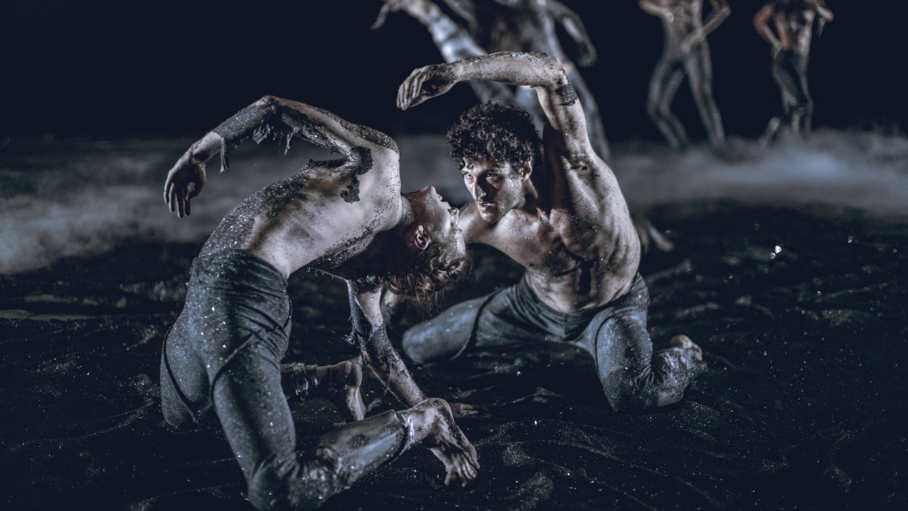Dancers on the ground on sand