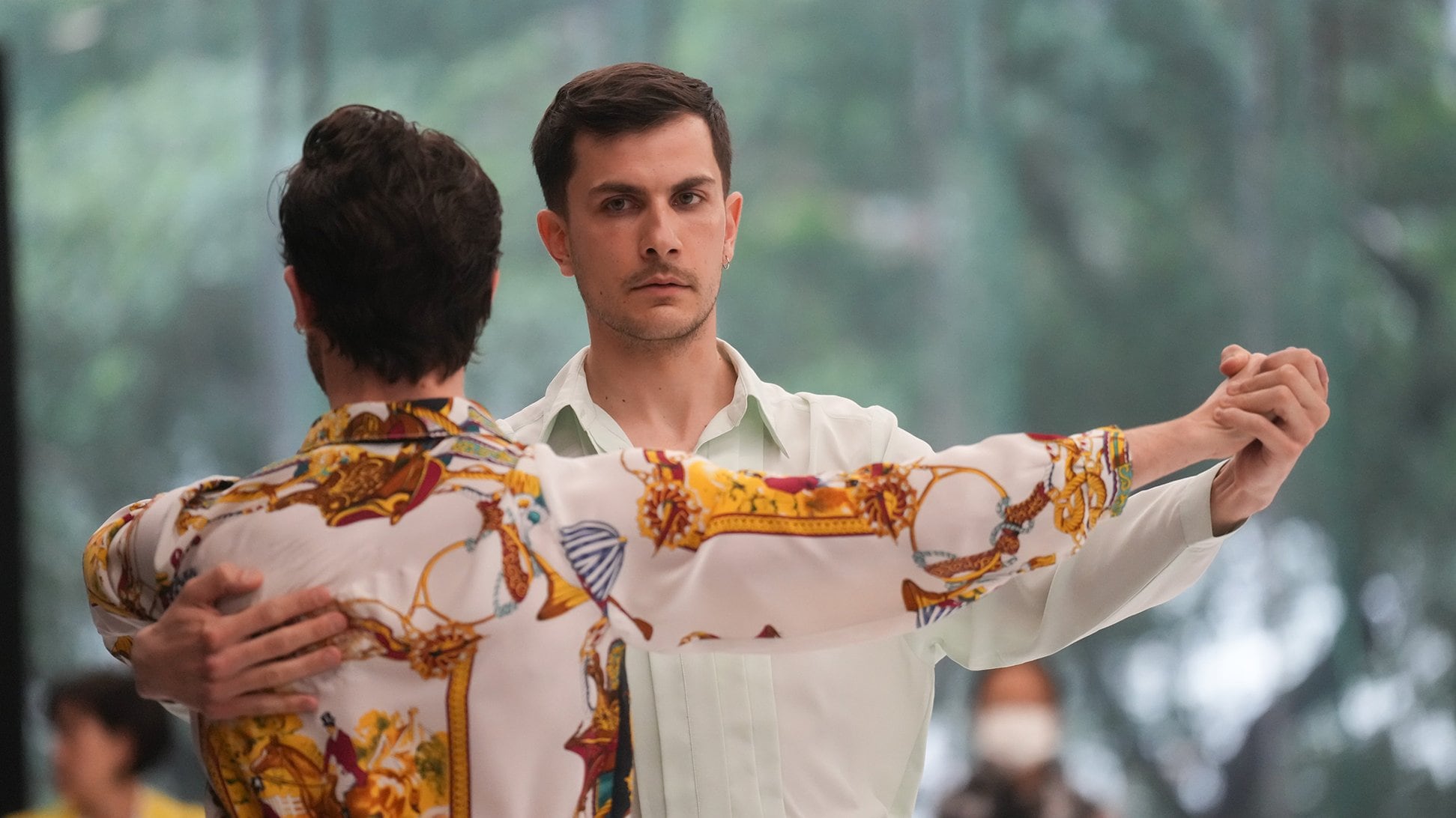Two dancers, one with their back to the viewer, the other facing forward.