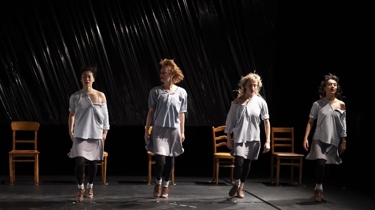 4 dancers standing in front of chairs 