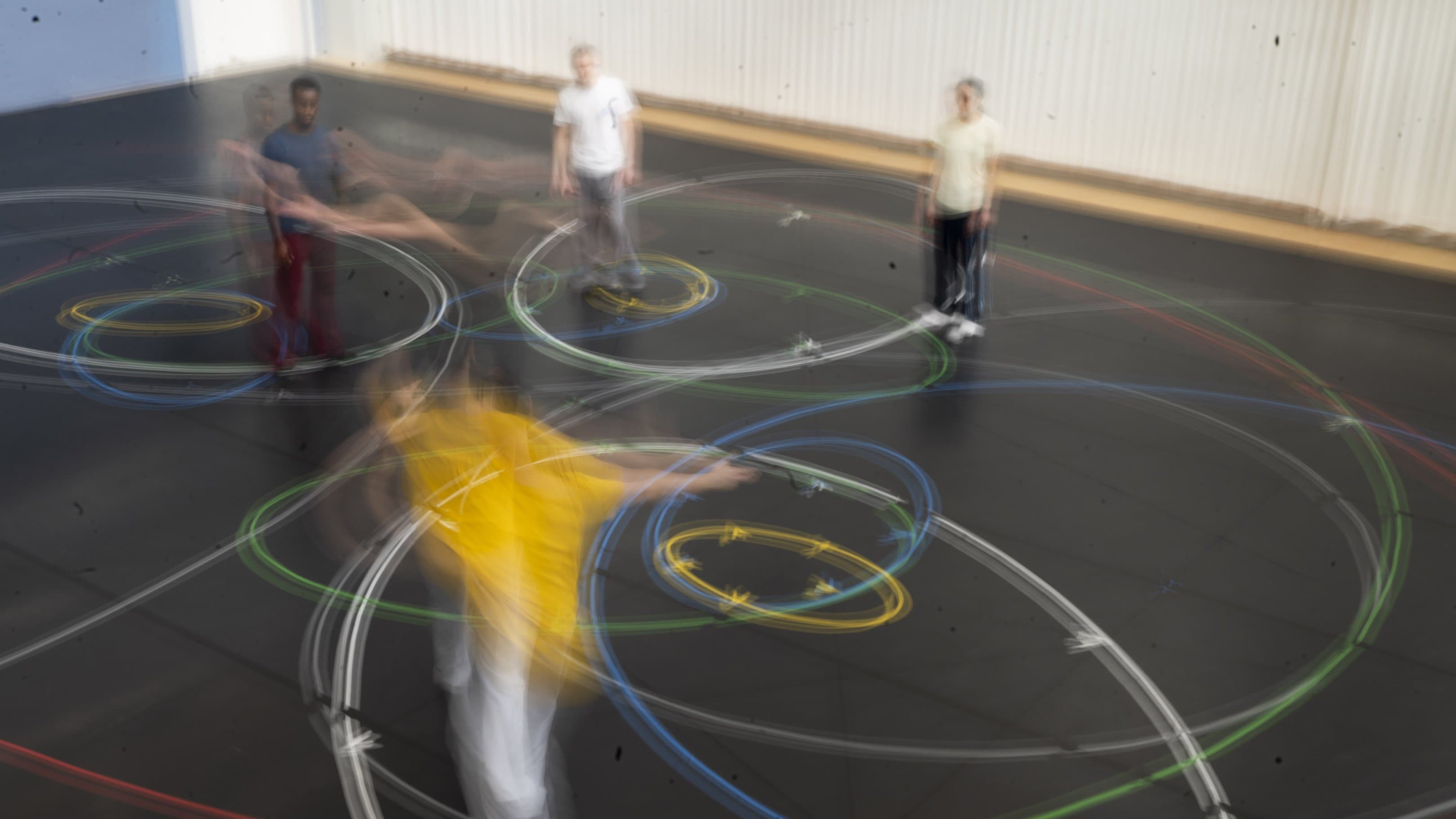 Personnes en mouvement créant des traînées lumineuses colorées