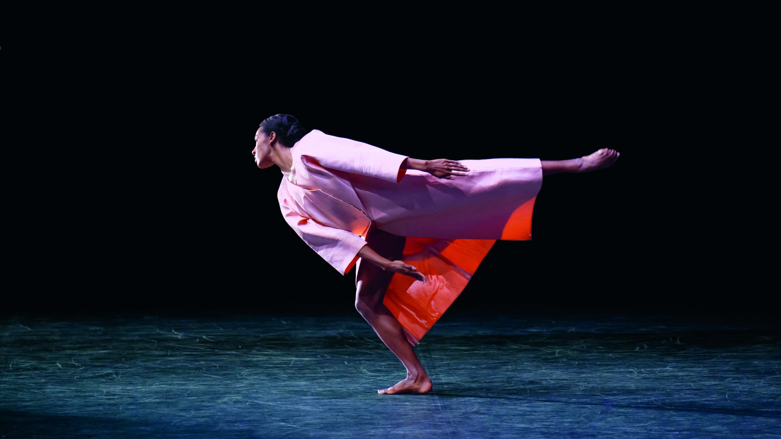 a dancer in a pink costume performing a pose