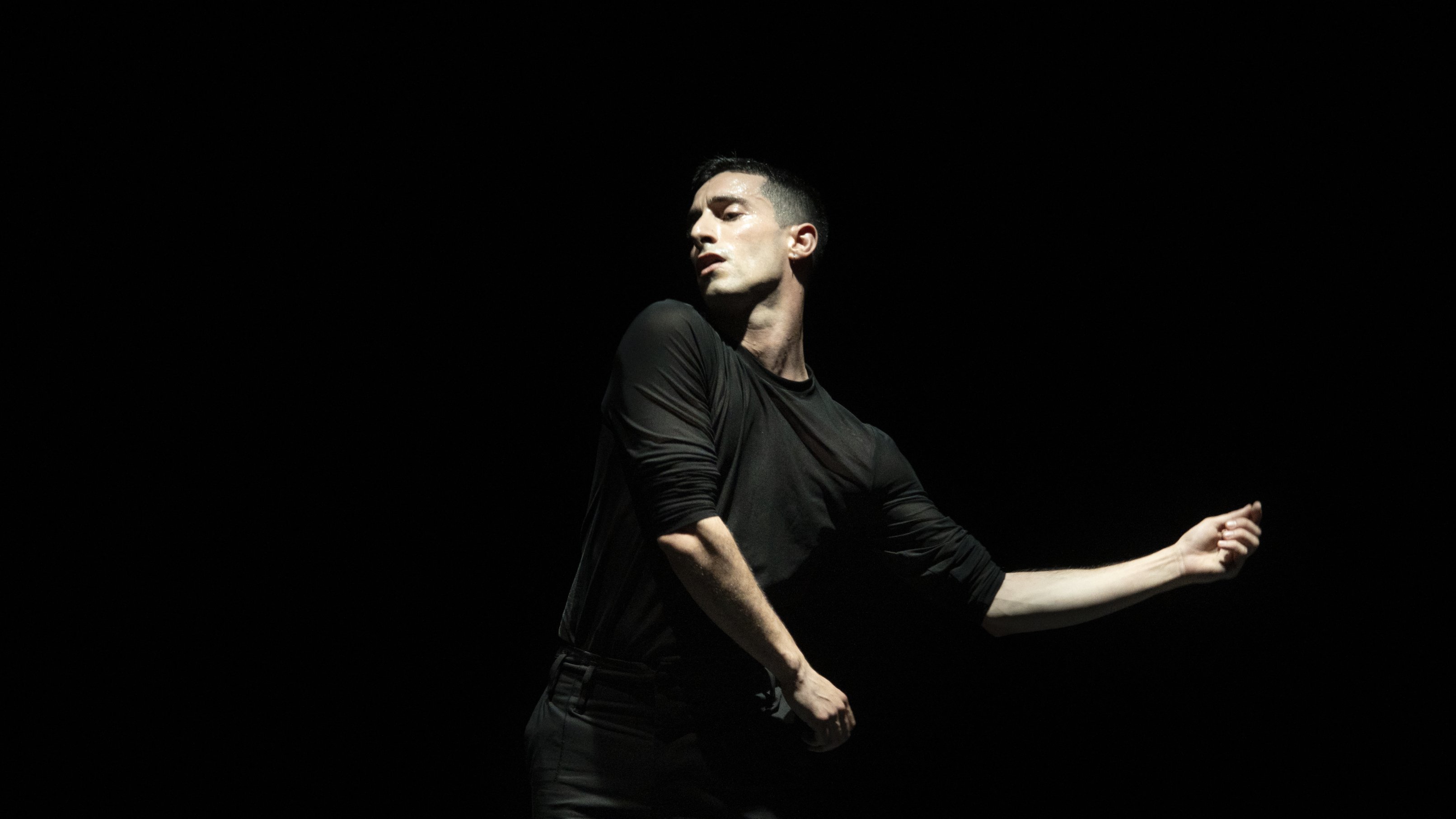 a dancer in black performing a solo 