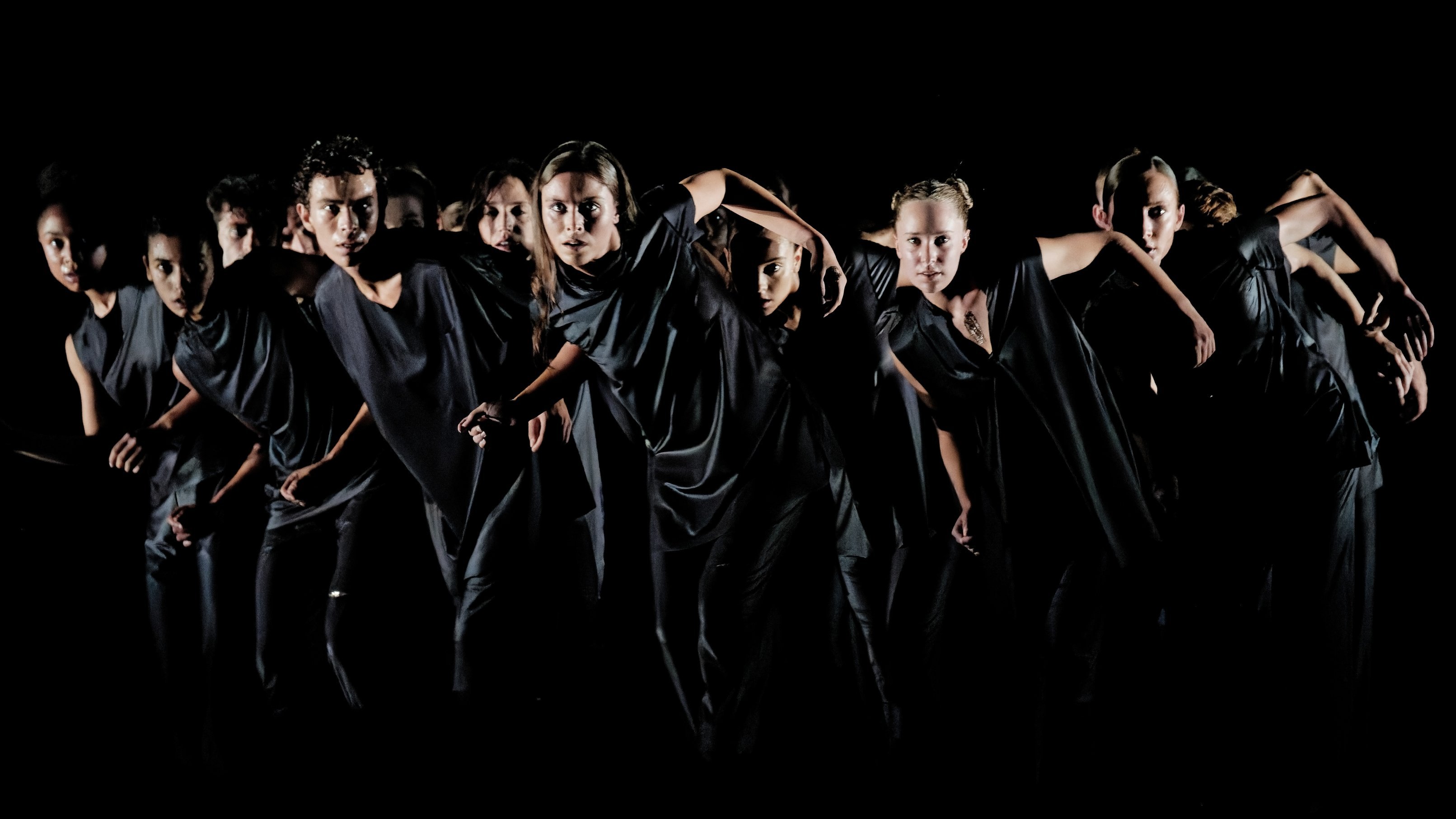 danseurs en noir avançant en groupe