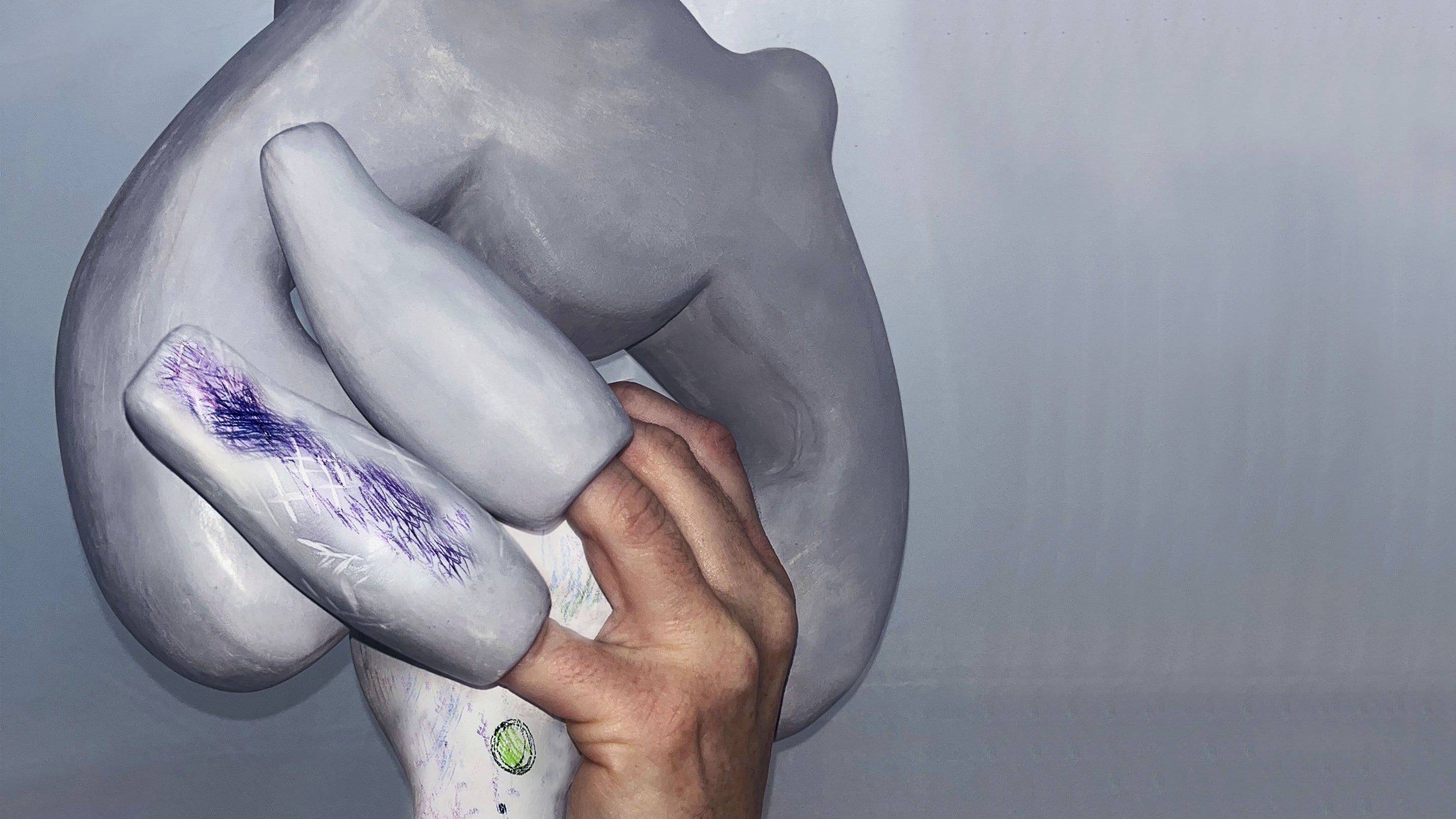 Hand holding a grey abstract sculpture