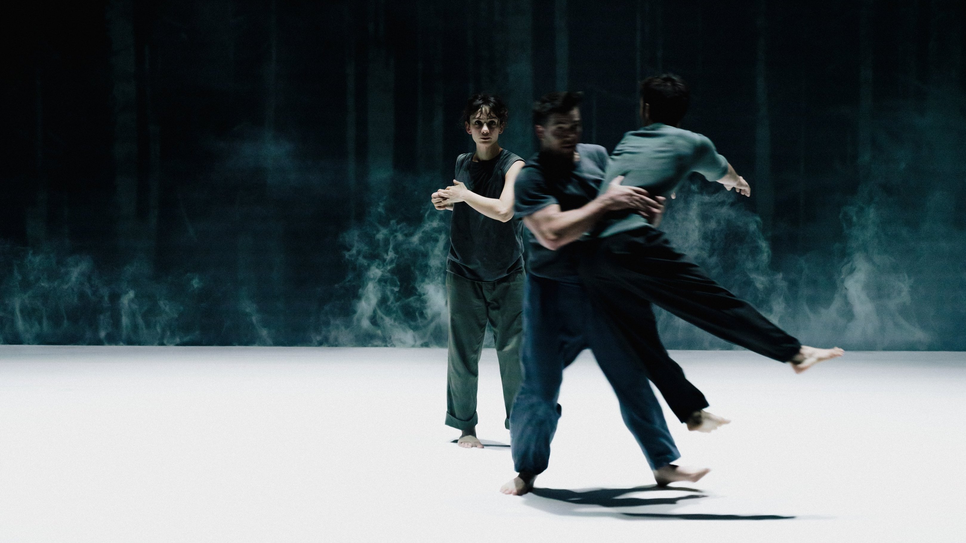 3 dancers in a misty atmosphere, in blue, white floor