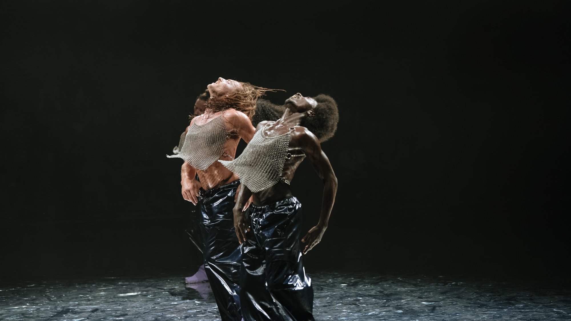 Deux danseurs la tête en arrière portant un tee shirt en cote de maille
