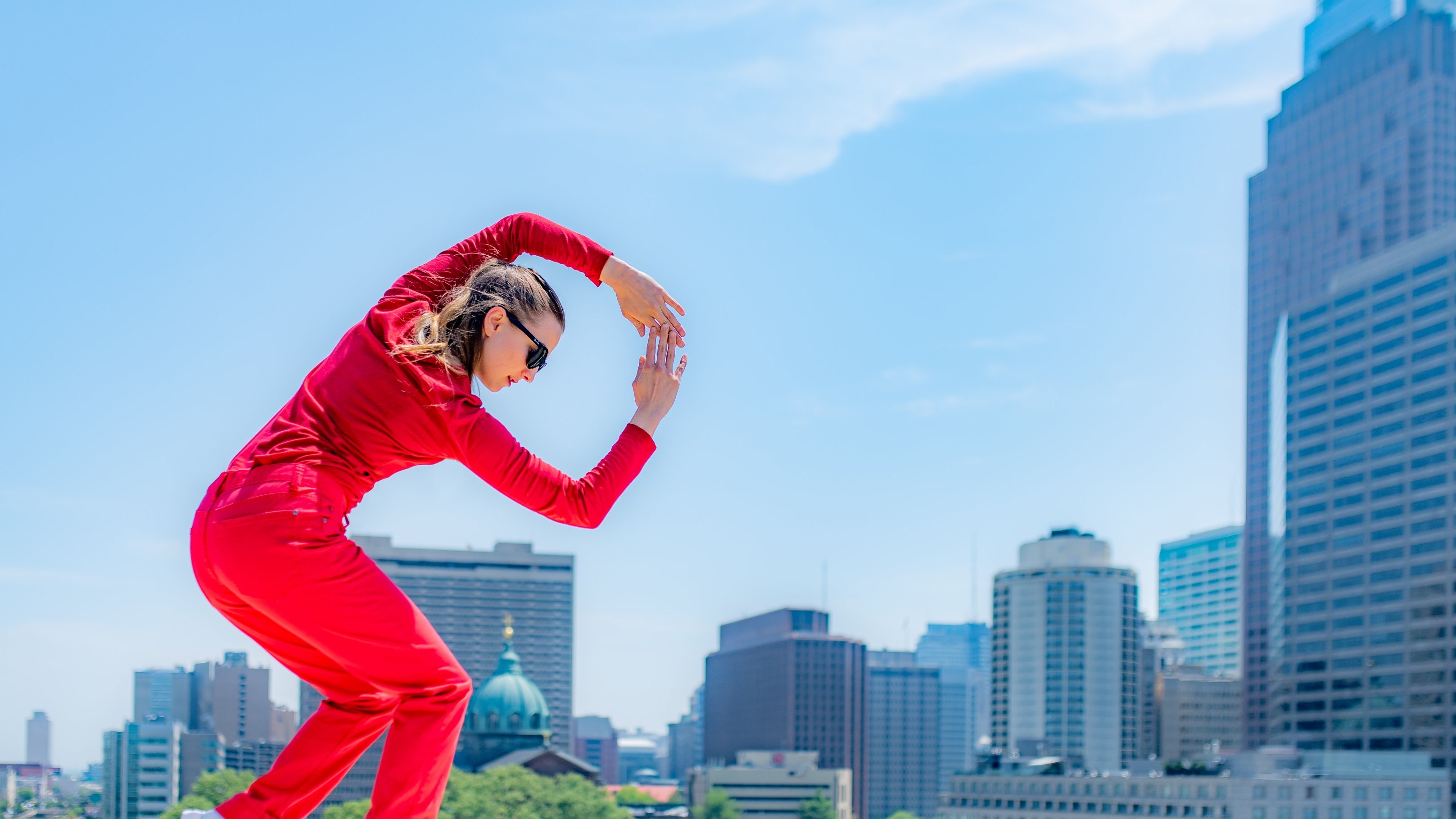 Danseuse sur un toit en costume rouge.  