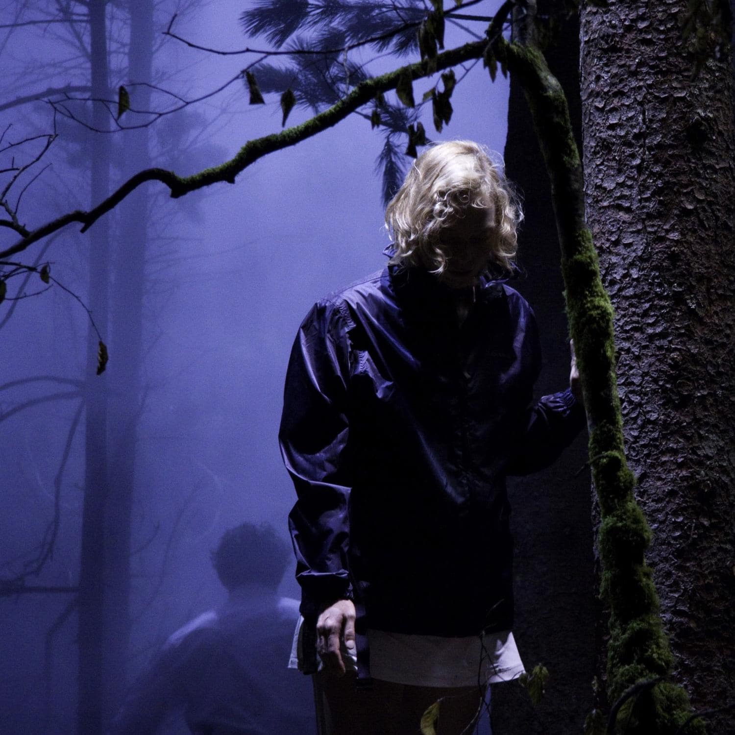 Blond woman in a forest by night