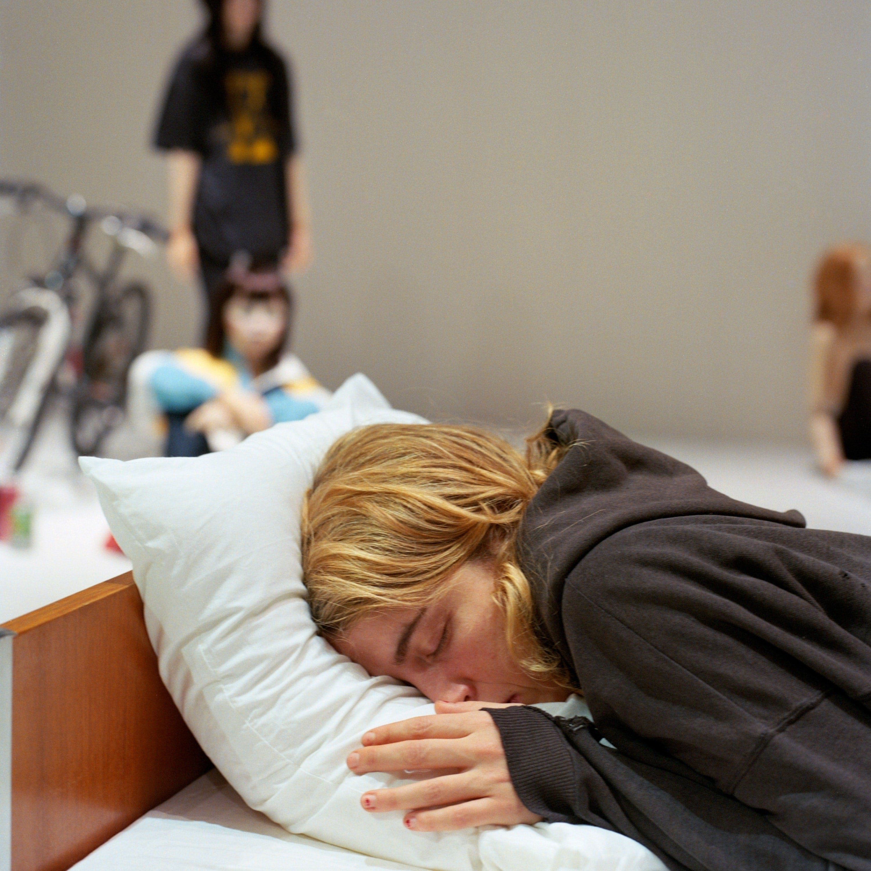 Gisèle Vienne作品《L’Étang》中躺在枕头上的年轻女子