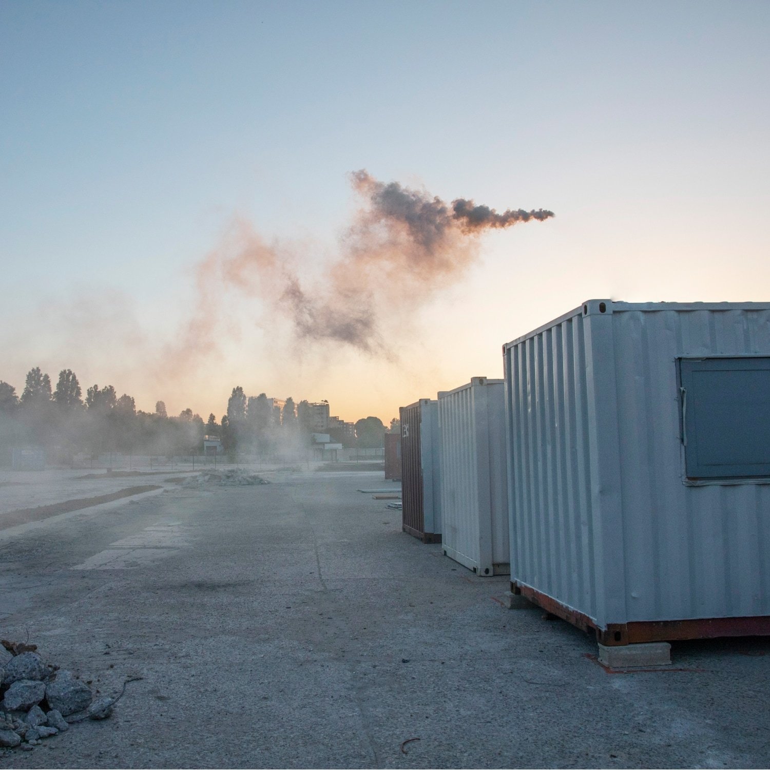 Containers on concrete, rubble and smoke