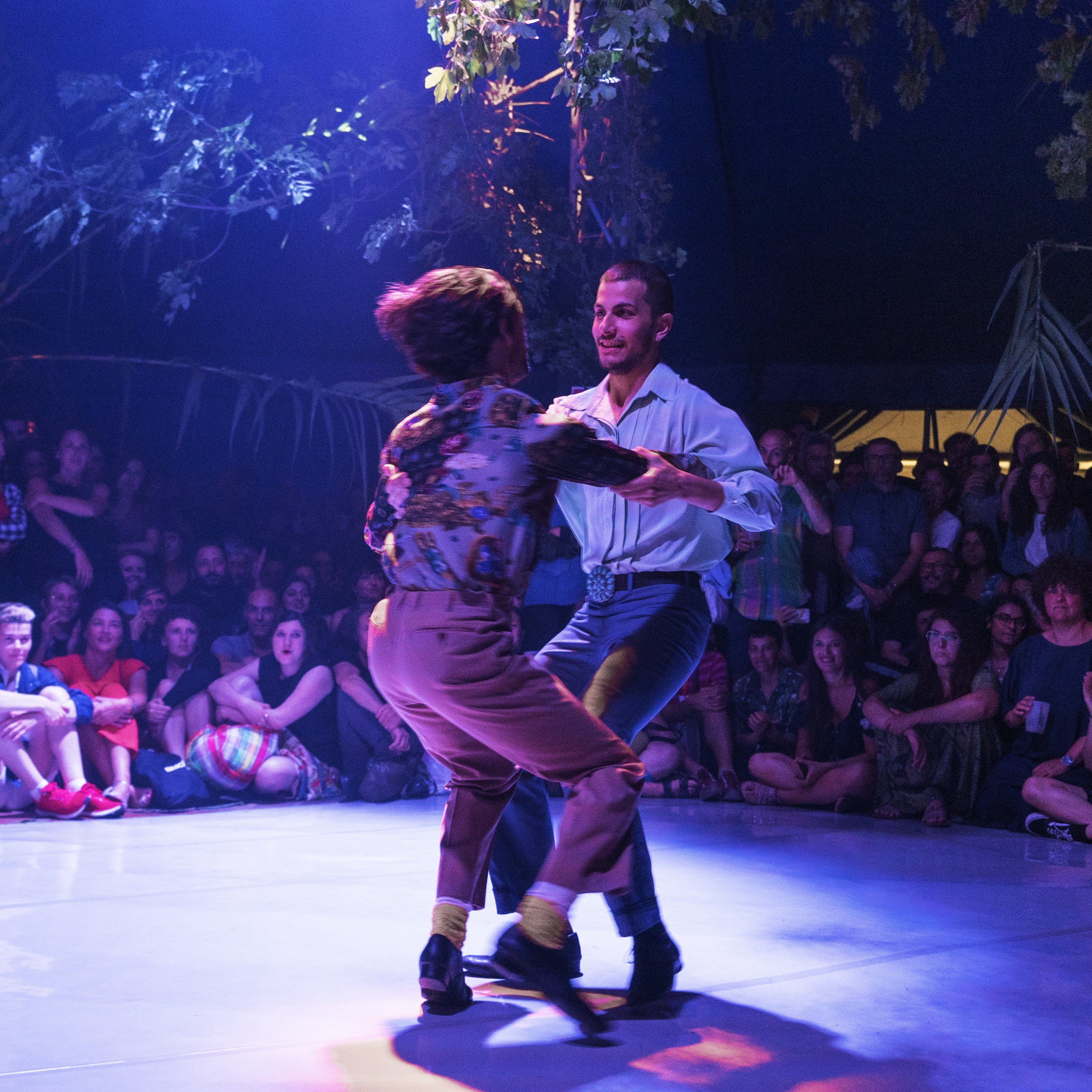 Deux danseurs tournoyant au milieu d'une foule