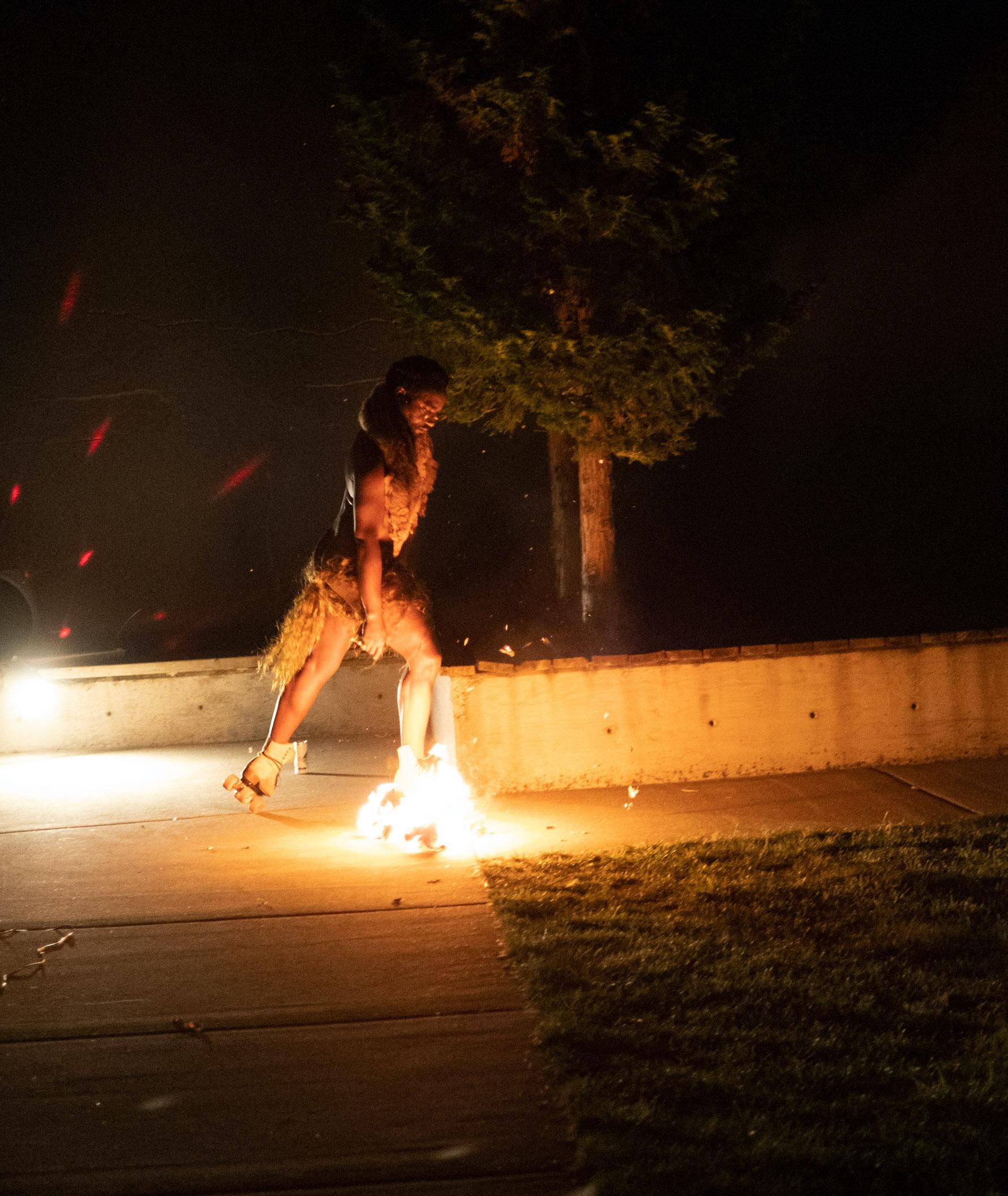 un danseur faisant du roller à la nuit tombée avec un patin en feu