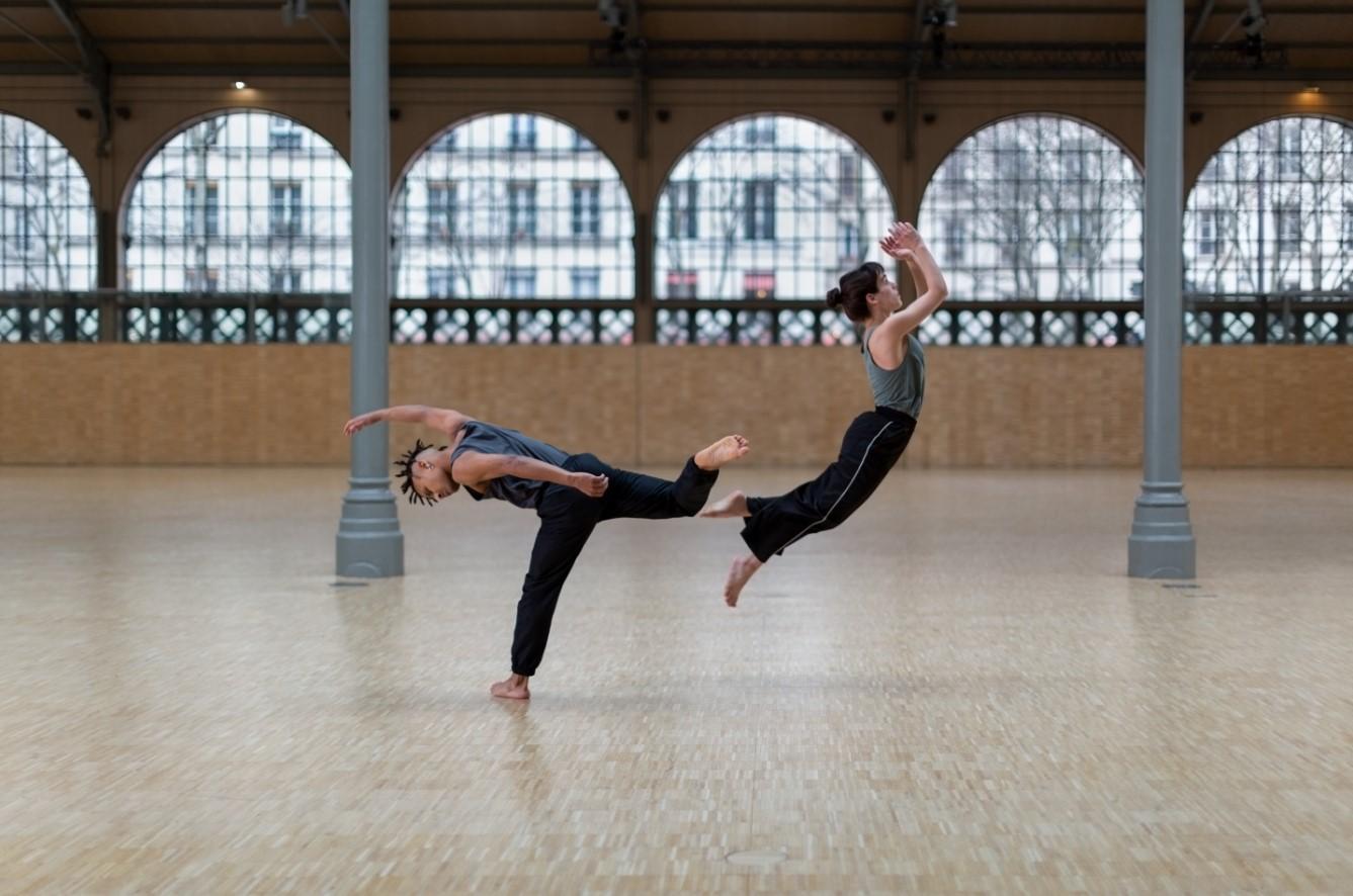 deux danseurs sautant dans des directions opposées 