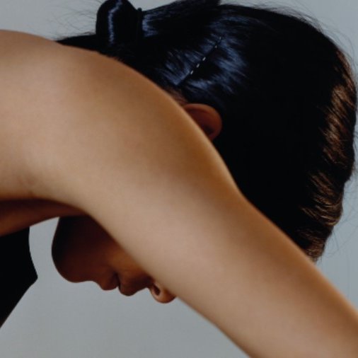 personne penchée en avant le bras cachant son visage