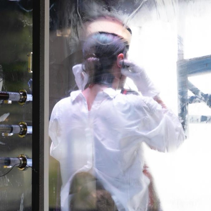 a person behind a glass with a white shirt