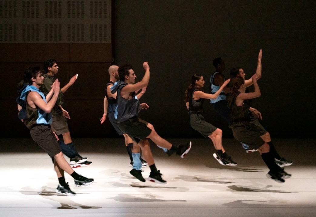 Danseurs sur scène sautent tous en même temps avec les bras levés