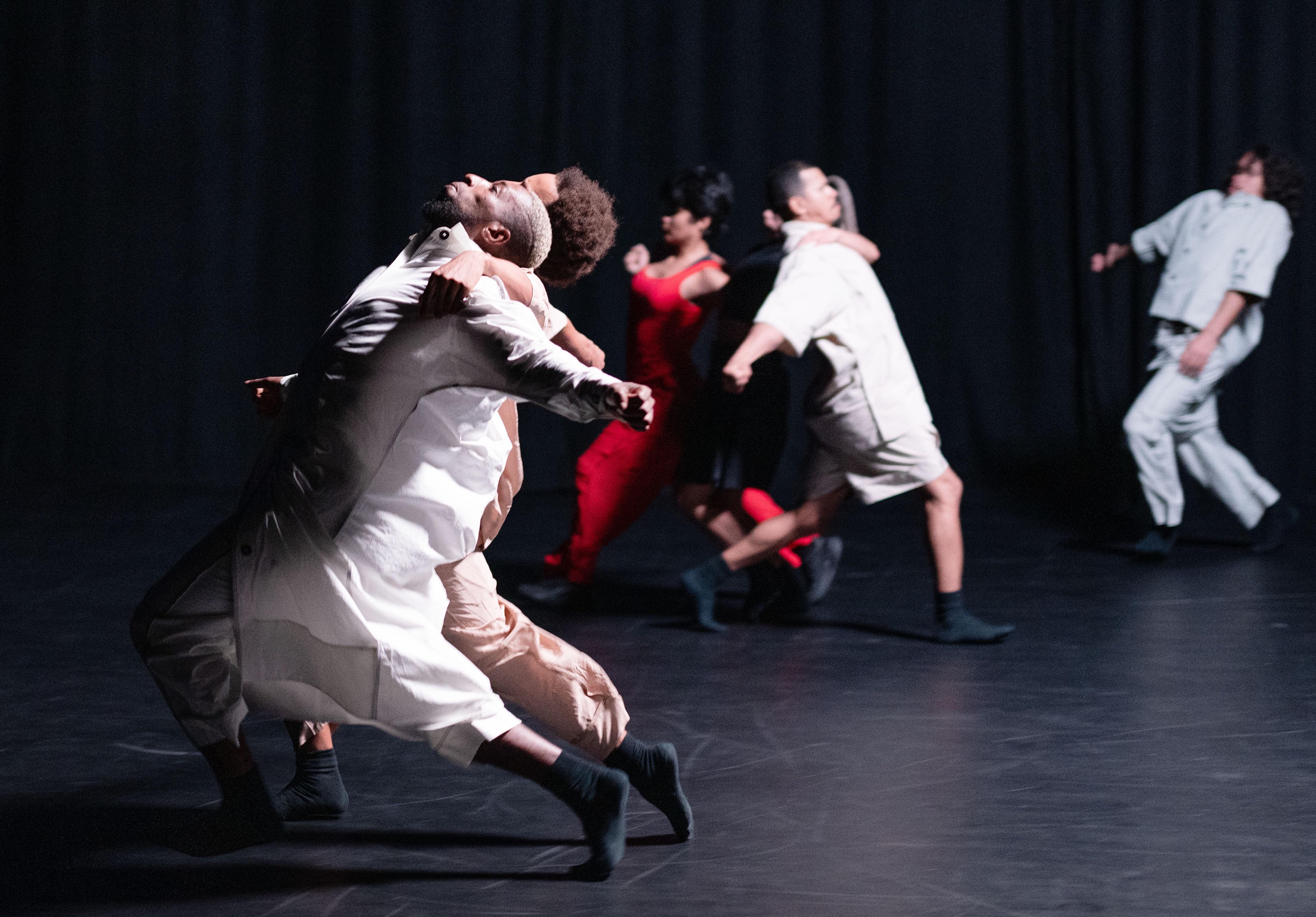 Danseurs vêtus de blanc, penchés vers l’arrière
