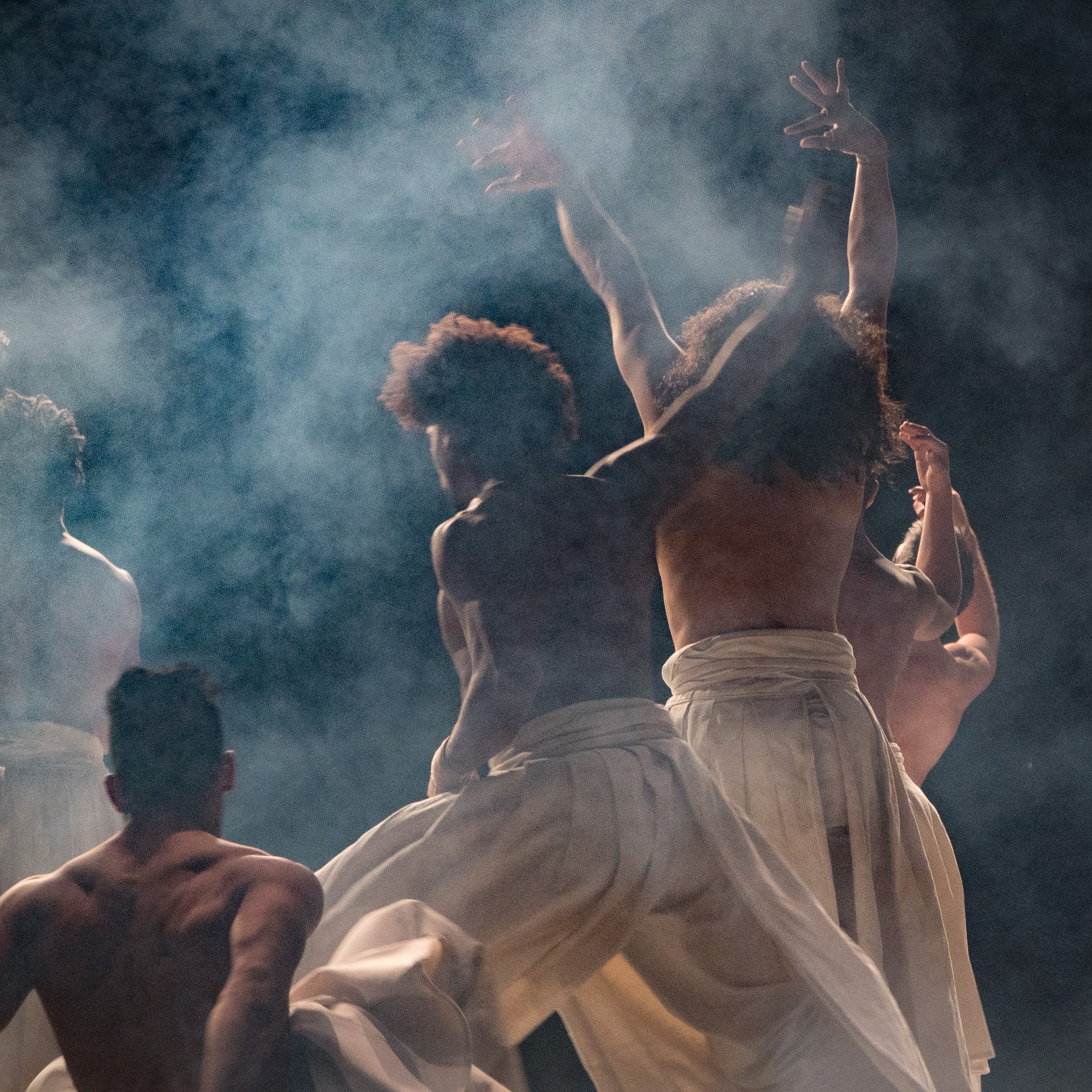Dancers wearing sirwal pants on a dark stage