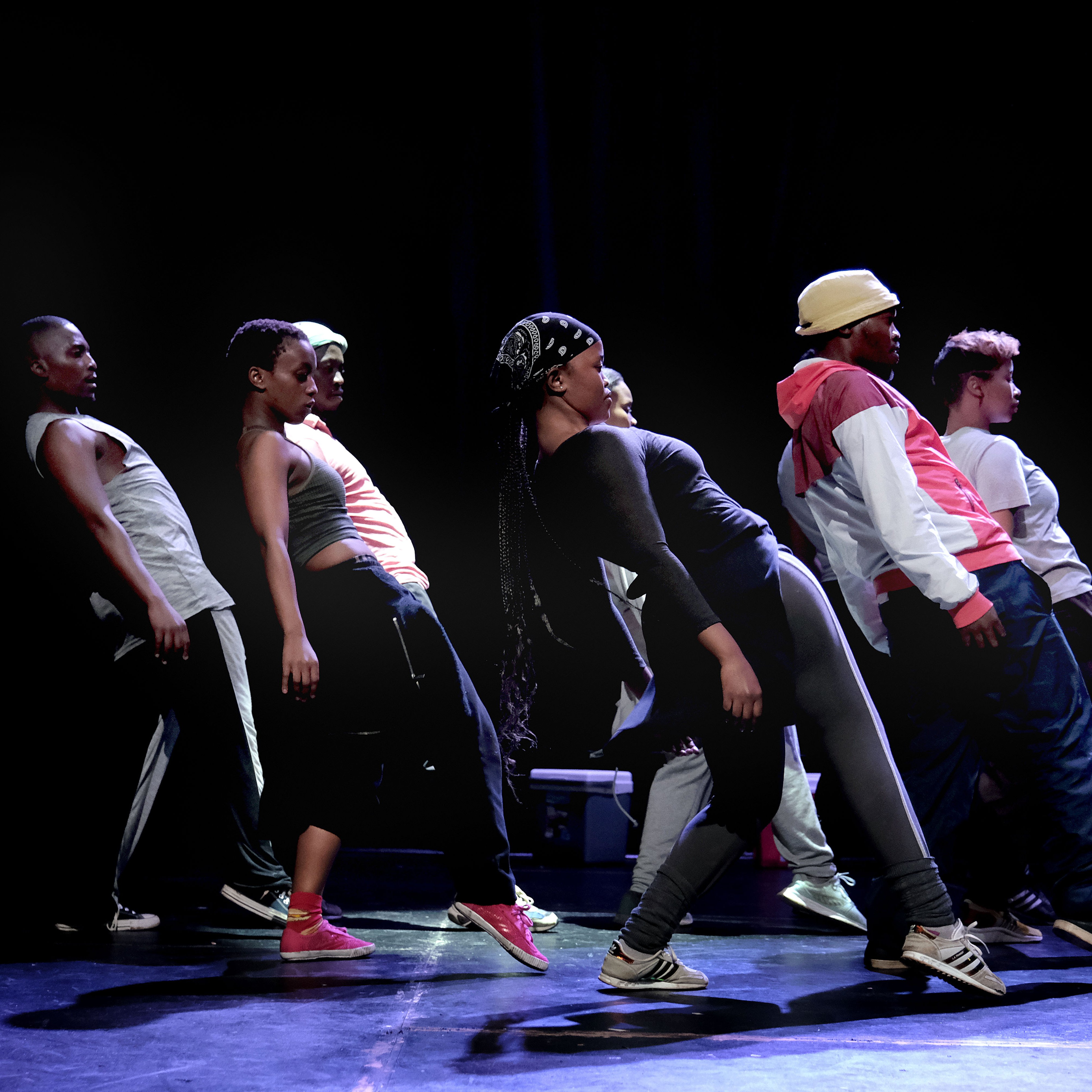 Dancers leaning backward with one leg stretched out in front in Via Injabulo